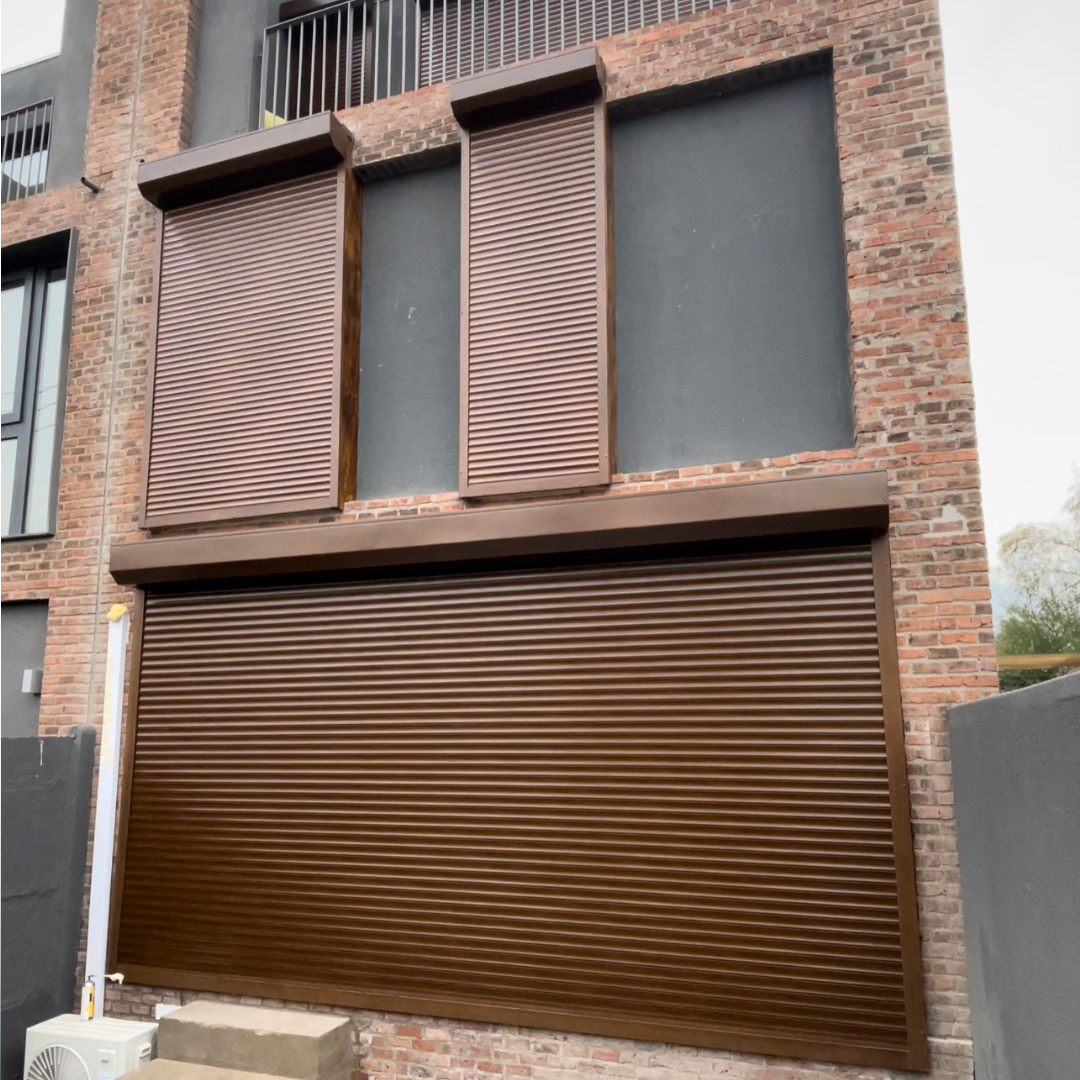 Cierre vertical tradicional de PVC transparente instalado en terraza moderna, con estructura negra y lona semi flexible, ideal para protección contra viento, lluvia y frío sin perder visibilidad exterior.