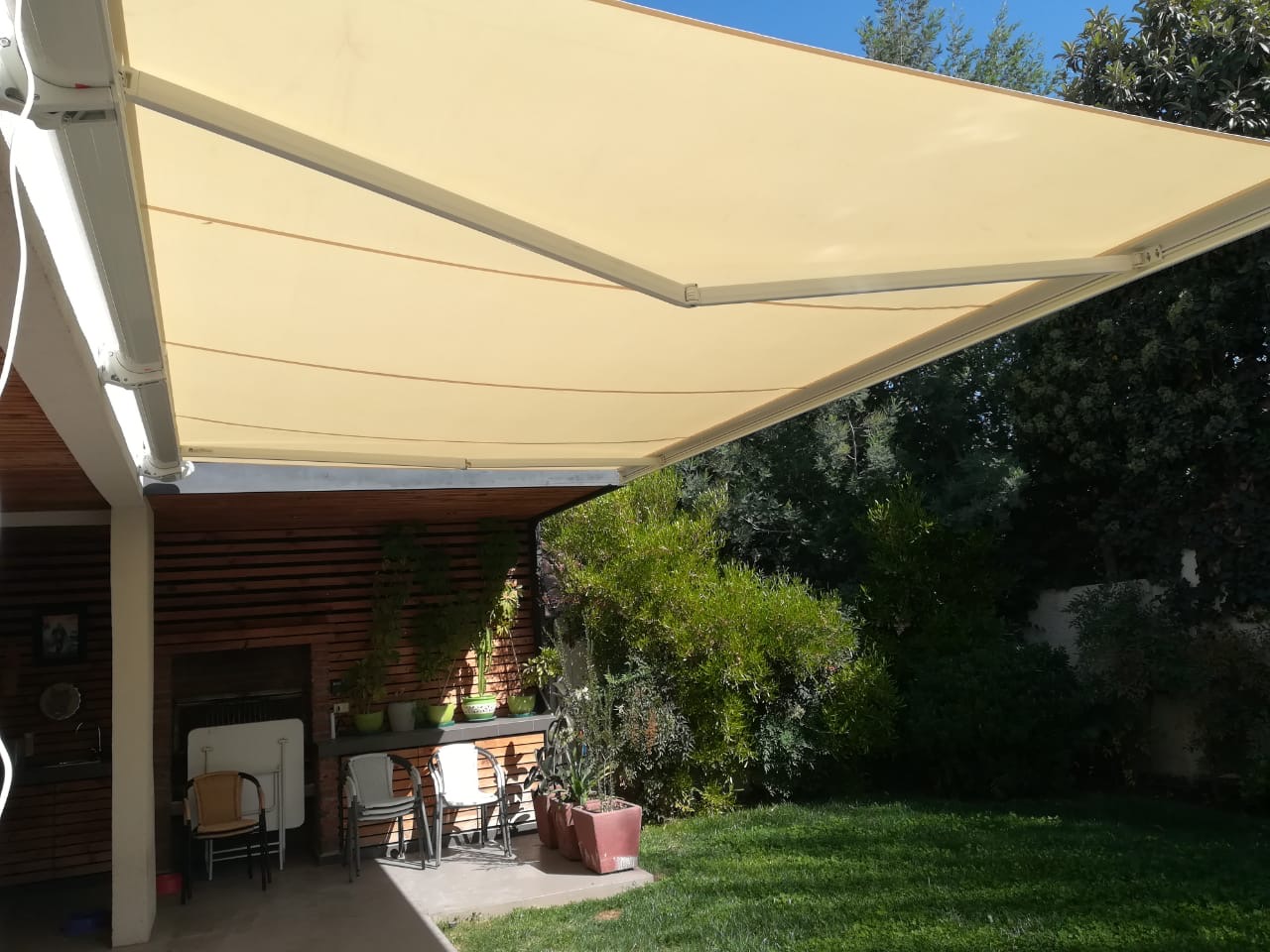 Terraza de departamento moderna con cierre de cristal plegable, amoblada con sofá. Terraza protegida del clima.