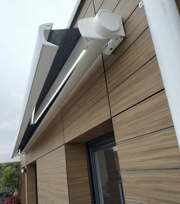 Terraza de departamento moderna con cierre de cristal plegable, amoblada con sofá. Terraza protegida del clima.