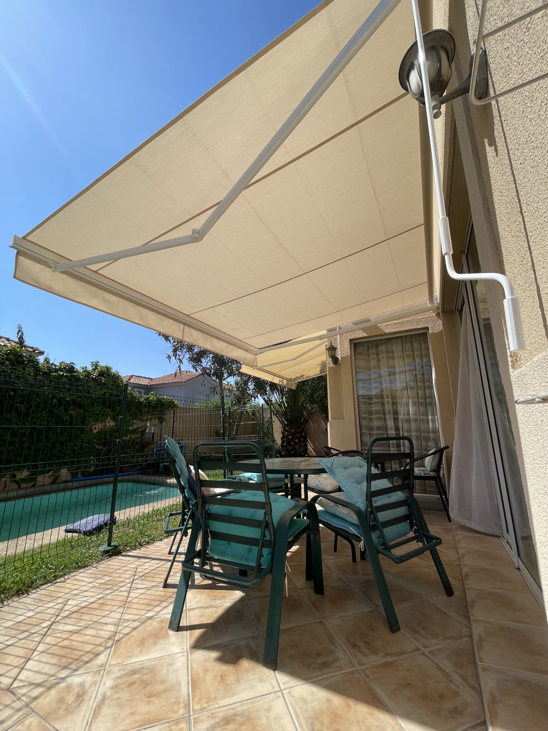 Terraza de departamento moderna con cierre de cristal plegable, amoblada con sofá. Terraza protegida del clima.