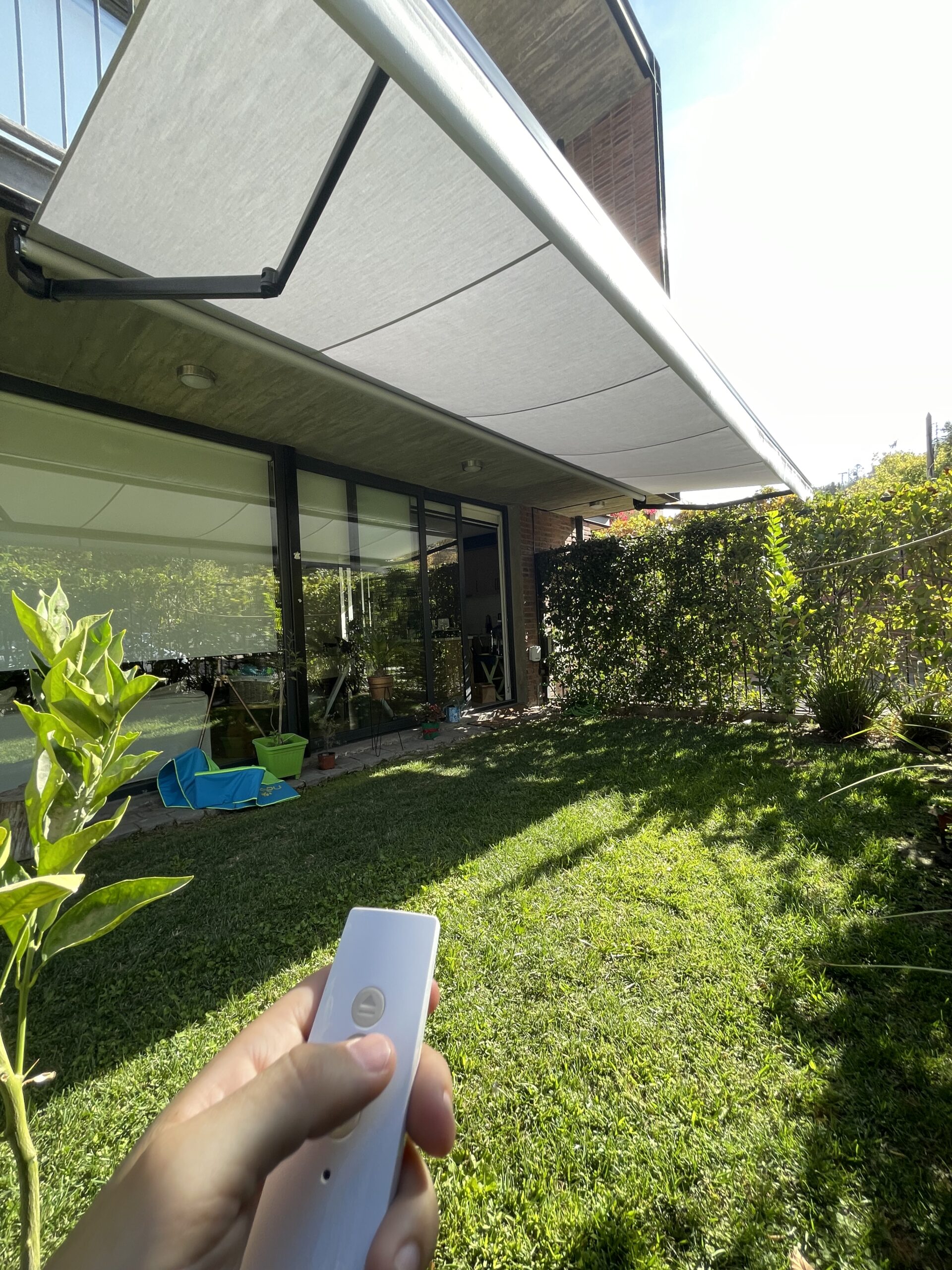 Terraza de departamento moderna con cierre de cristal plegable, amoblada con sofá. Terraza protegida del clima.