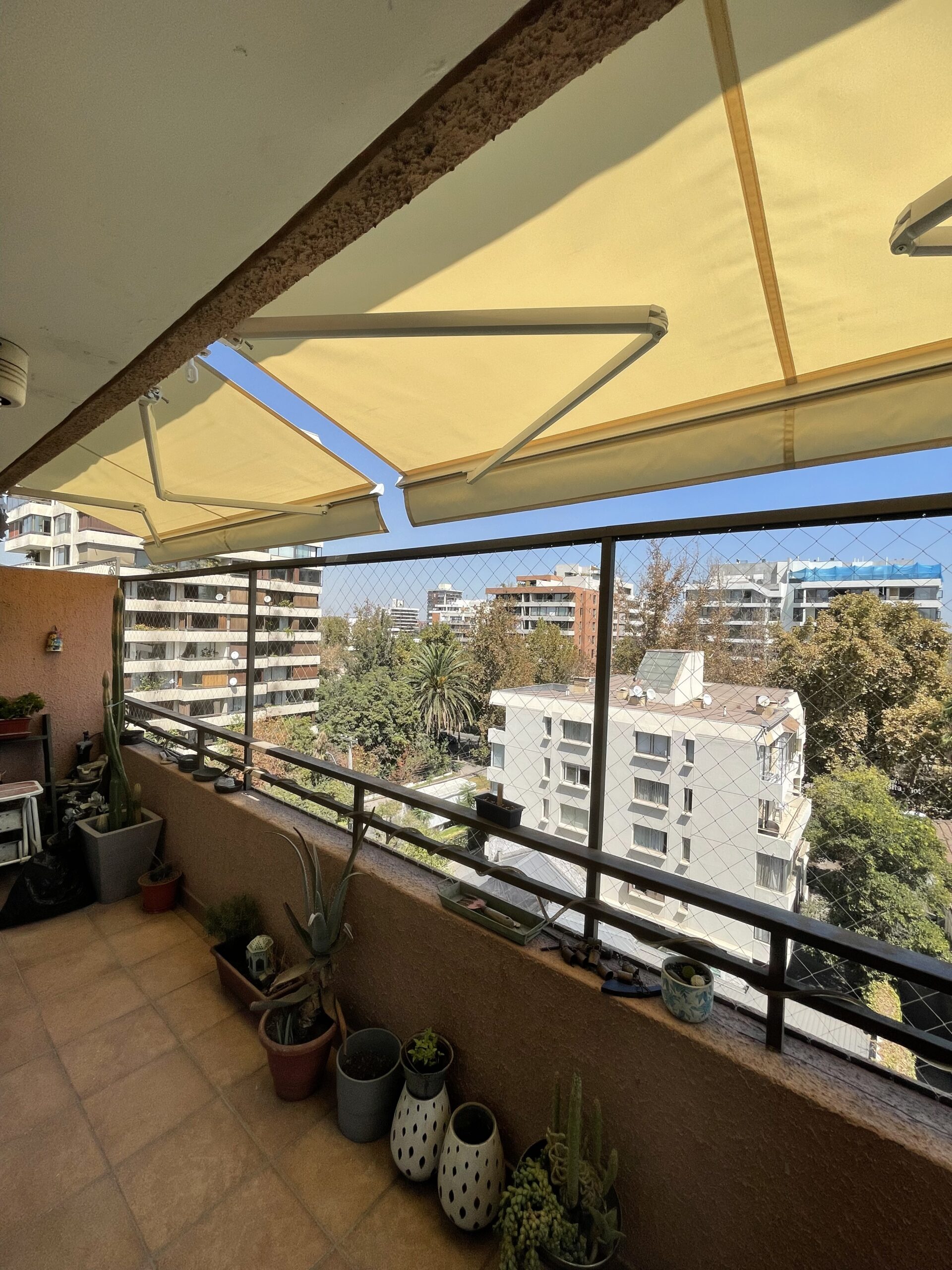 Terraza de departamento moderna con cierre de cristal plegable, amoblada con sofá. Terraza protegida del clima.