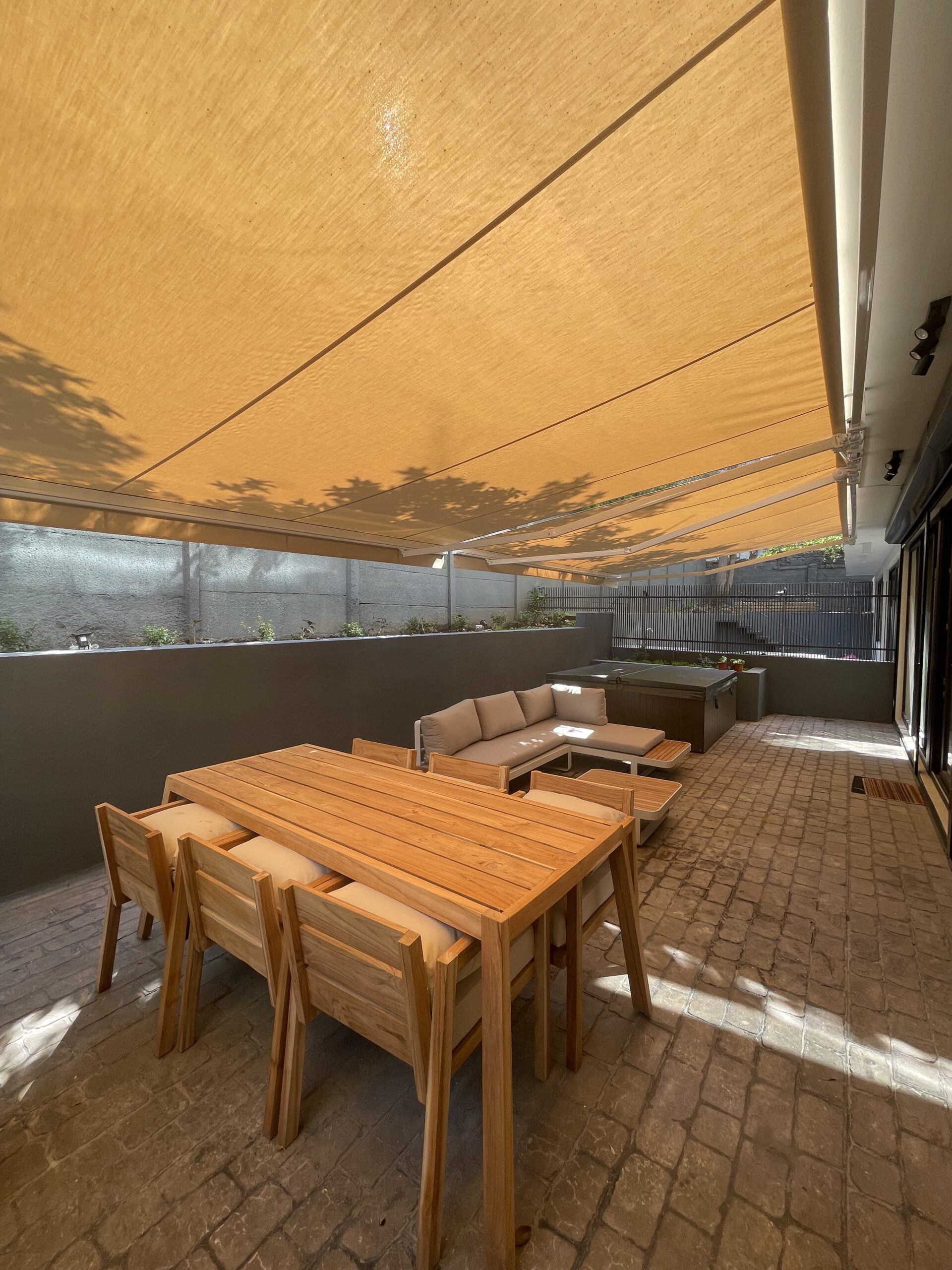 Terraza de departamento moderna con cierre de cristal plegable, amoblada con sofá. Terraza protegida del clima.