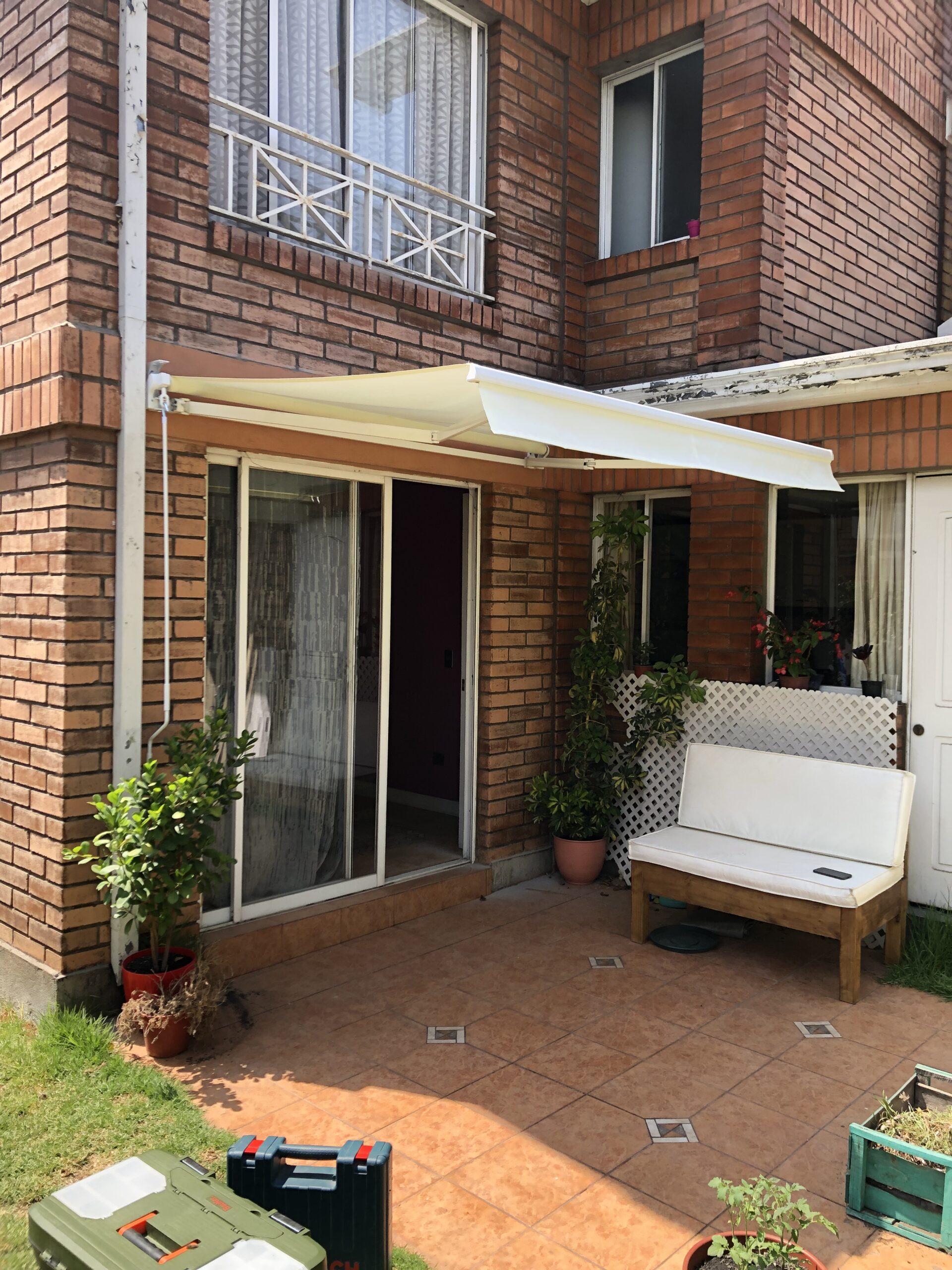 Terraza de departamento moderna con cierre de cristal plegable, amoblada con sofá. Terraza protegida del clima.