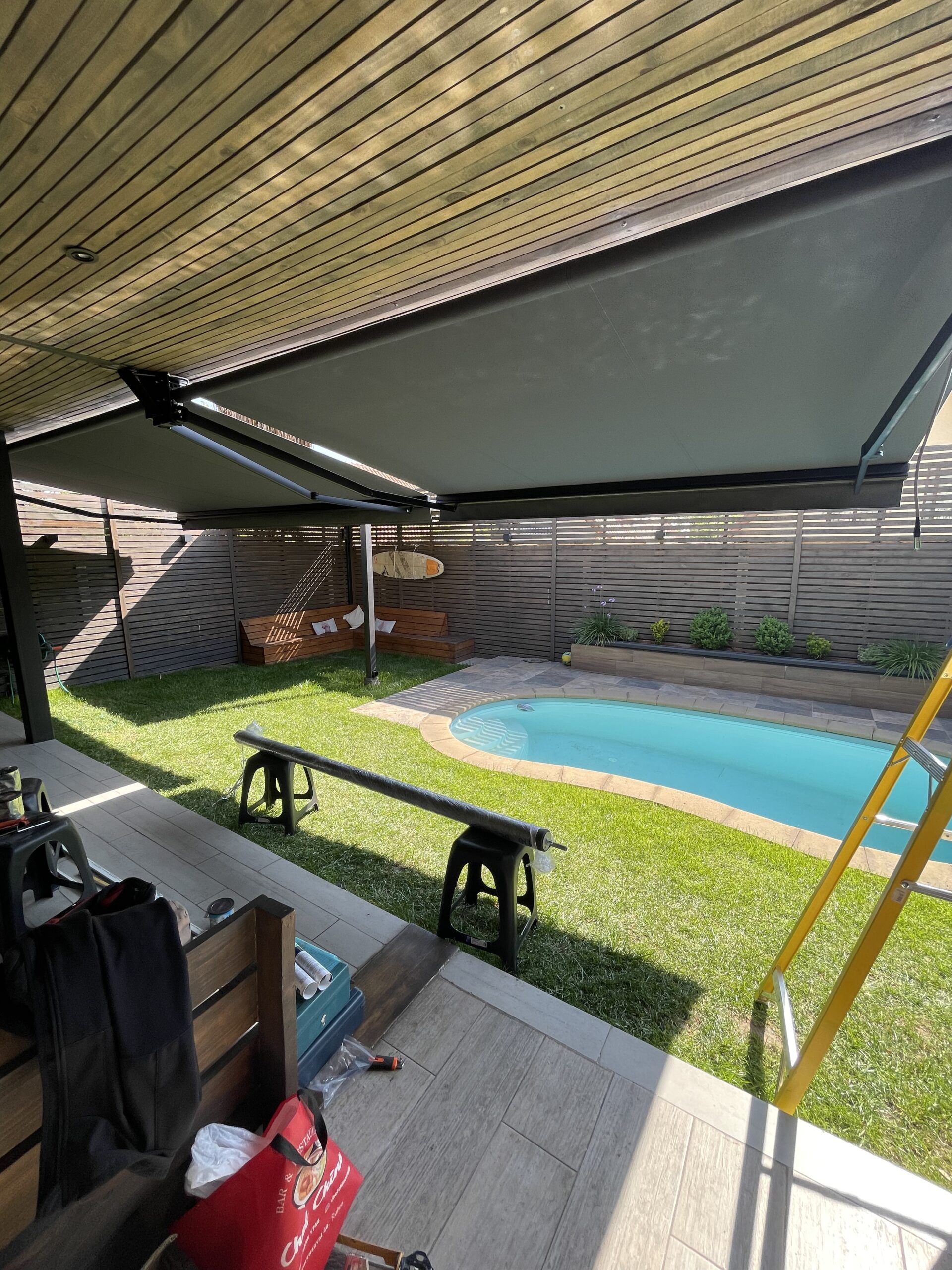 Terraza de departamento moderna con cierre de cristal plegable, amoblada con sofá. Terraza protegida del clima.