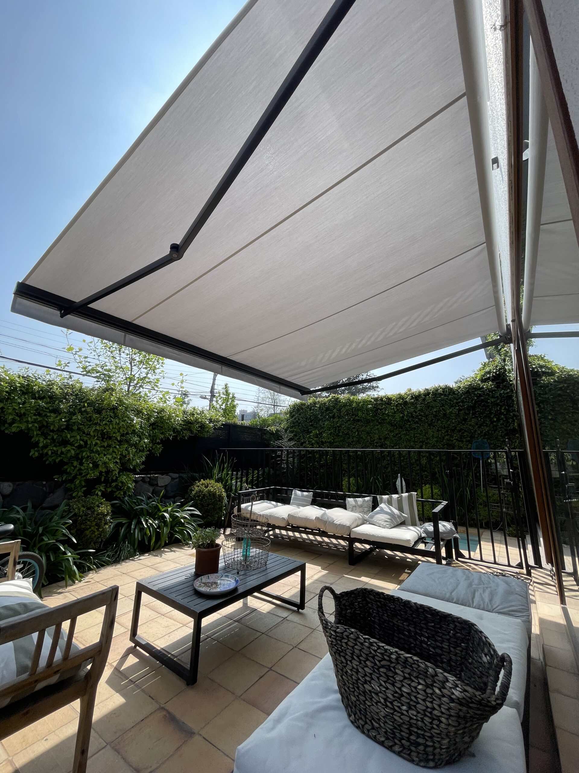 Terraza de departamento moderna con cierre de cristal plegable, amoblada con sofá. Terraza protegida del clima.