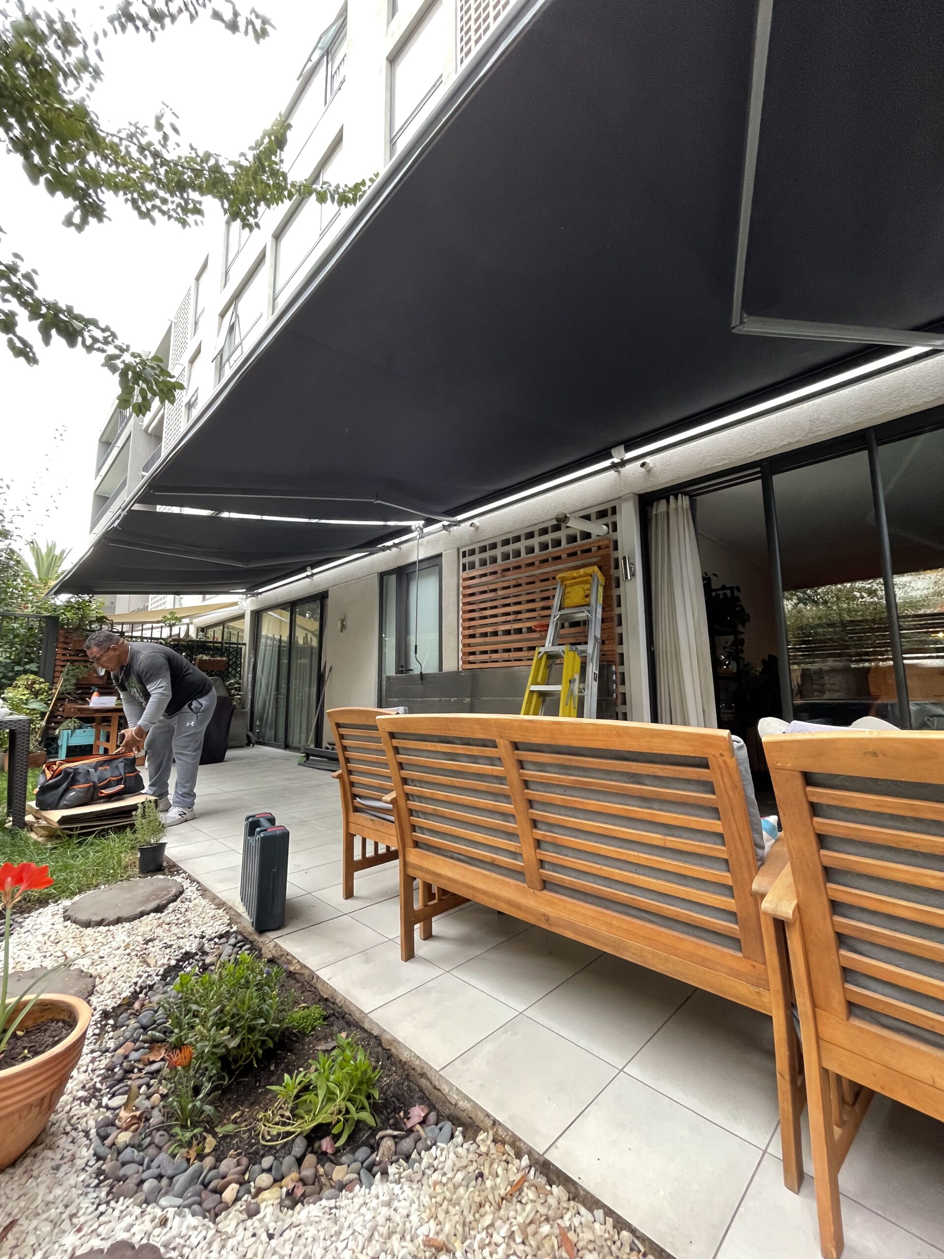 Terraza de departamento moderna con cierre de cristal plegable, amoblada con sofá. Terraza protegida del clima.