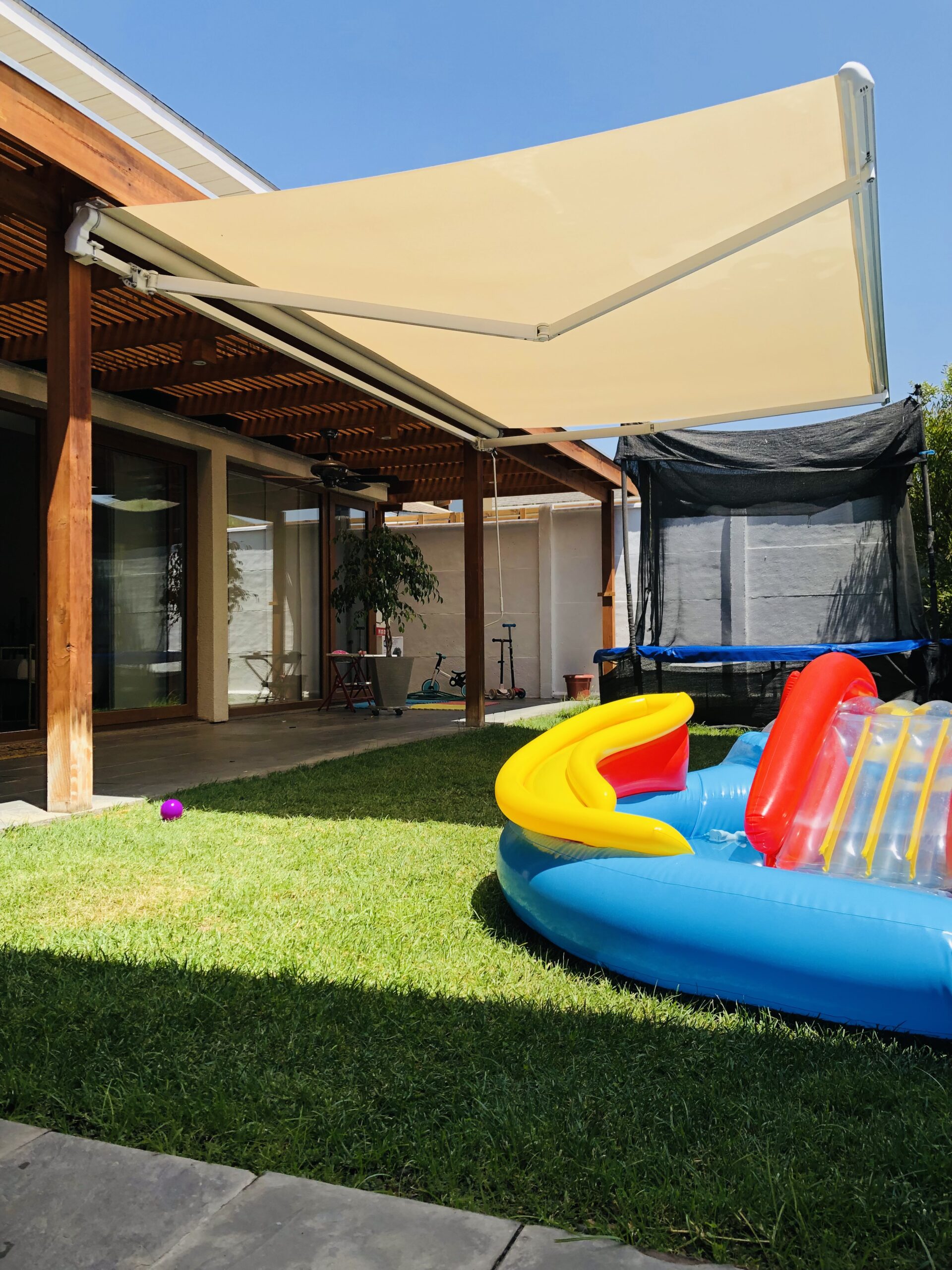 Terraza de departamento moderna con cierre de cristal plegable, amoblada con sofá. Terraza protegida del clima.