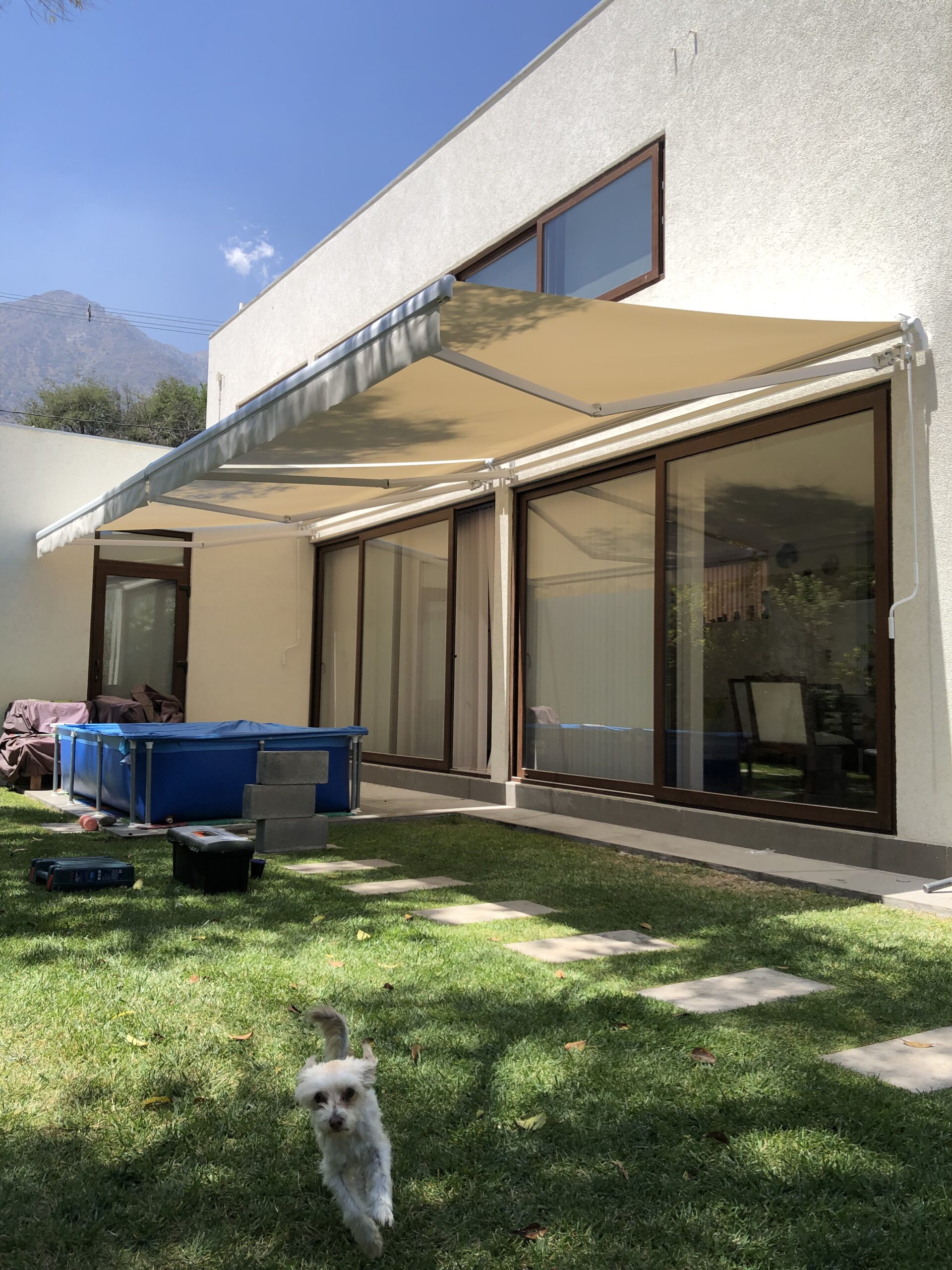 Terraza de departamento moderna con cierre de cristal plegable, amoblada con sofá. Terraza protegida del clima.