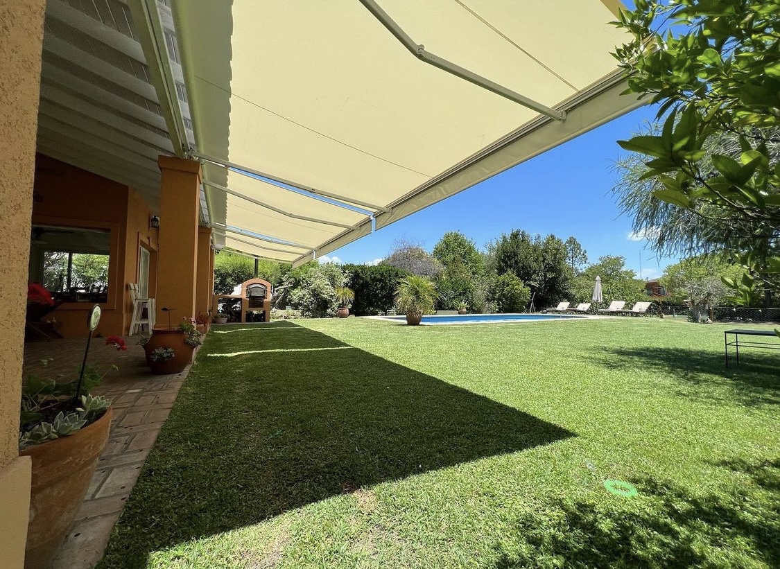 Terraza de departamento moderna con cierre de cristal plegable, amoblada con sofá. Terraza protegida del clima.