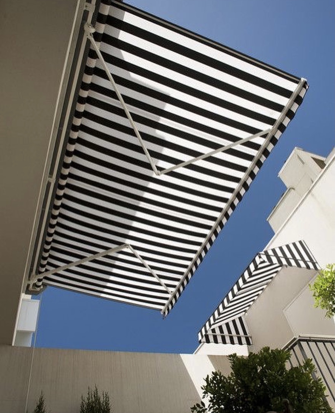 Terraza de departamento moderna con cierre de cristal plegable, amoblada con sofá. Terraza protegida del clima.