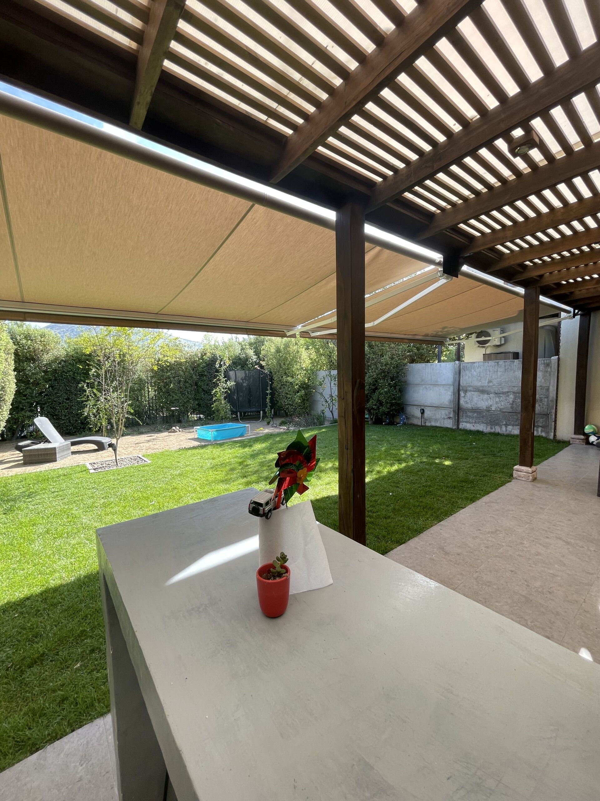 Terraza de departamento moderna con cierre de cristal plegable, amoblada con sofá. Terraza protegida del clima.