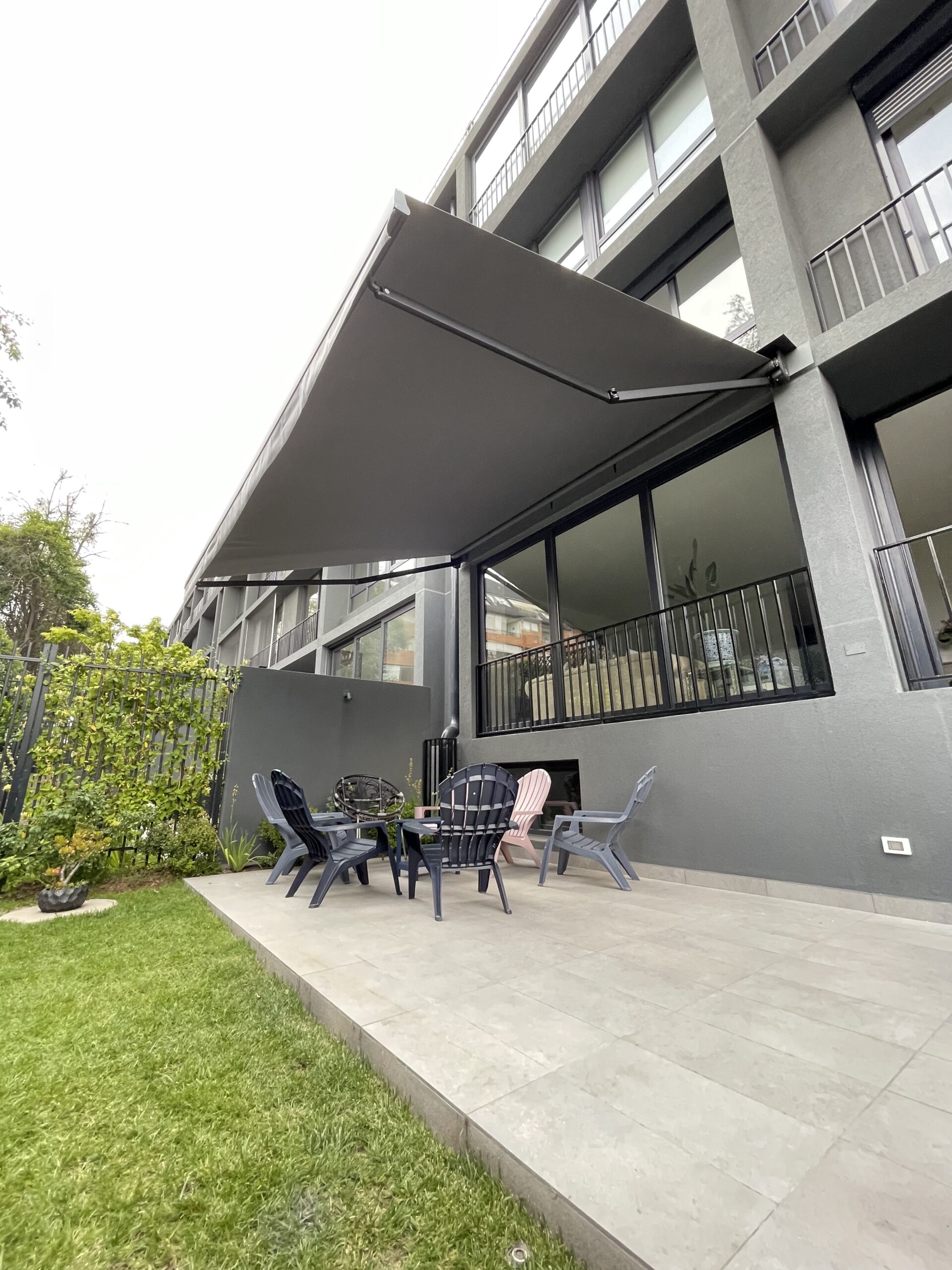 Terraza de departamento moderna con cierre de cristal plegable, amoblada con sofá. Terraza protegida del clima.