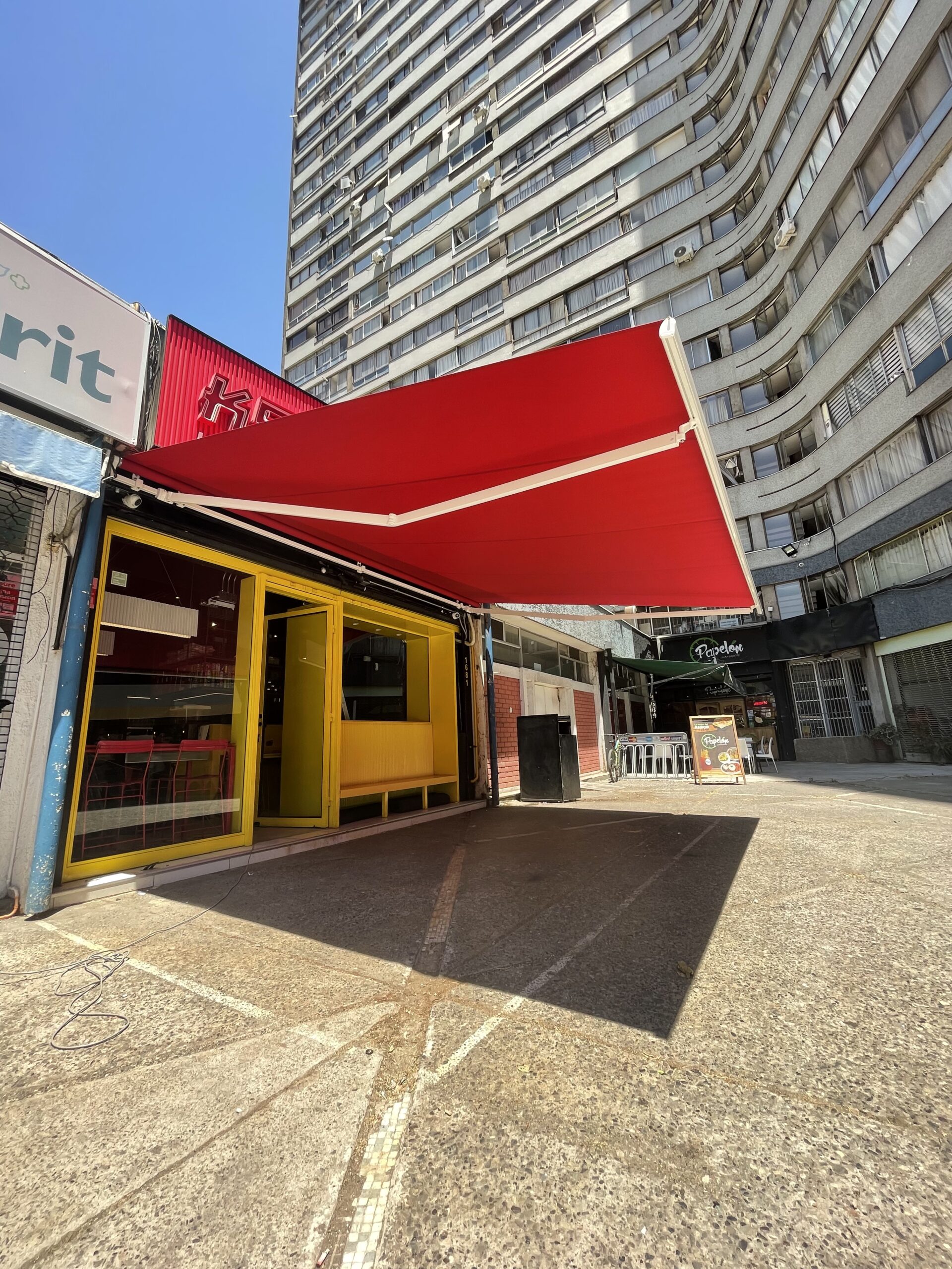 Terraza de departamento moderna con cierre de cristal plegable, amoblada con sofá. Terraza protegida del clima.