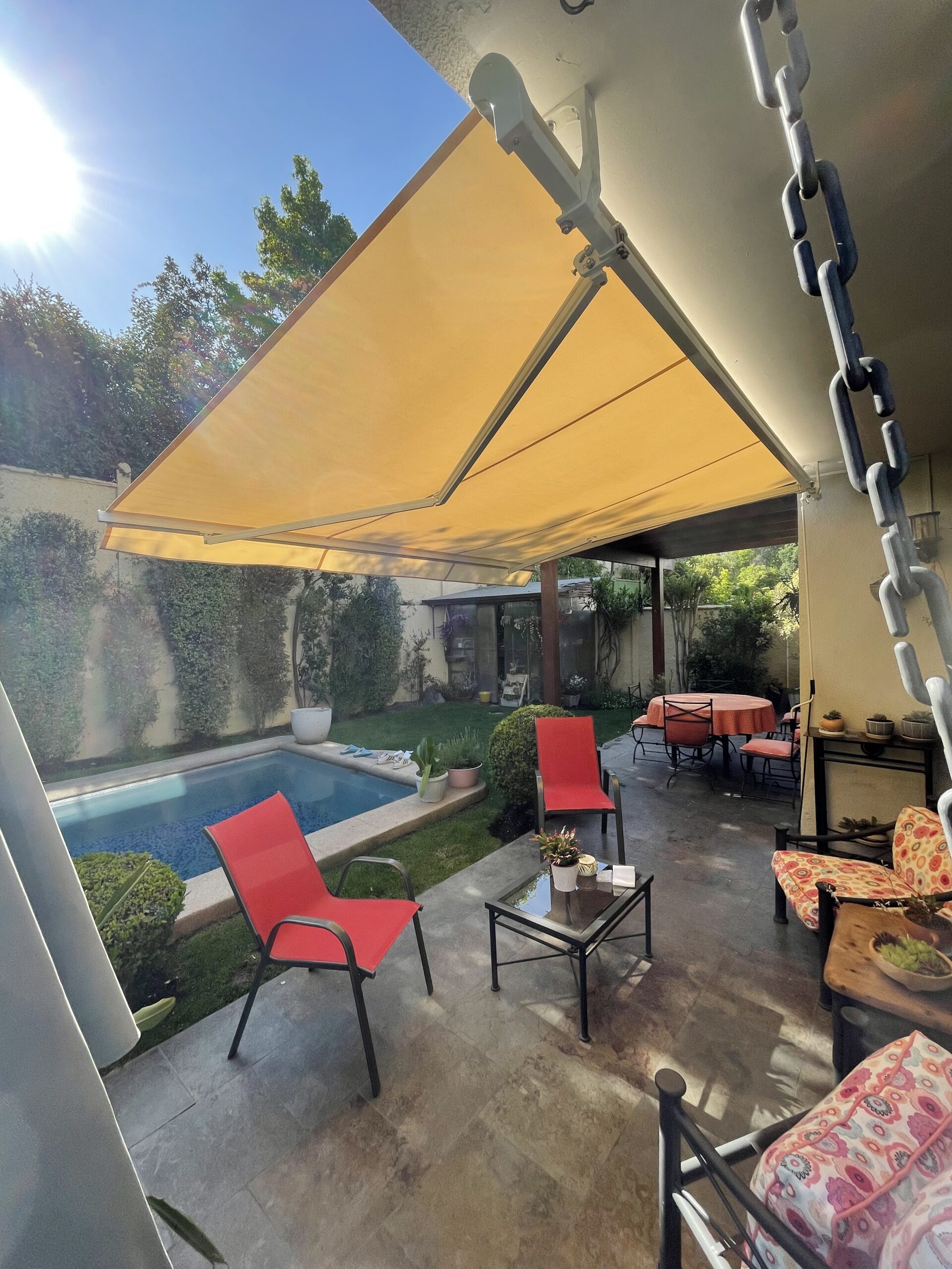 Terraza de departamento moderna con cierre de cristal plegable, amoblada con sofá. Terraza protegida del clima.