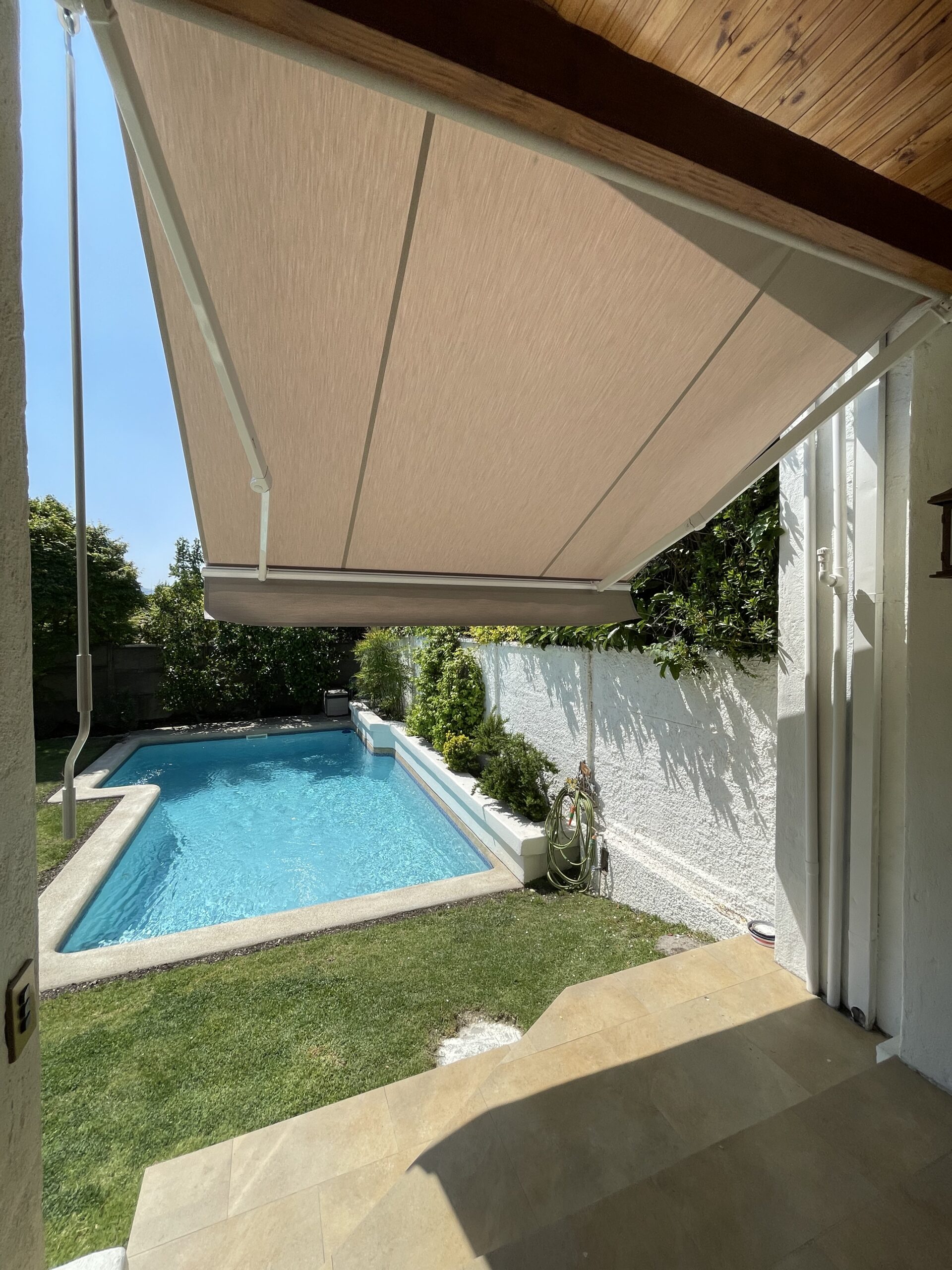 Terraza de departamento moderna con cierre de cristal plegable, amoblada con sofá. Terraza protegida del clima.