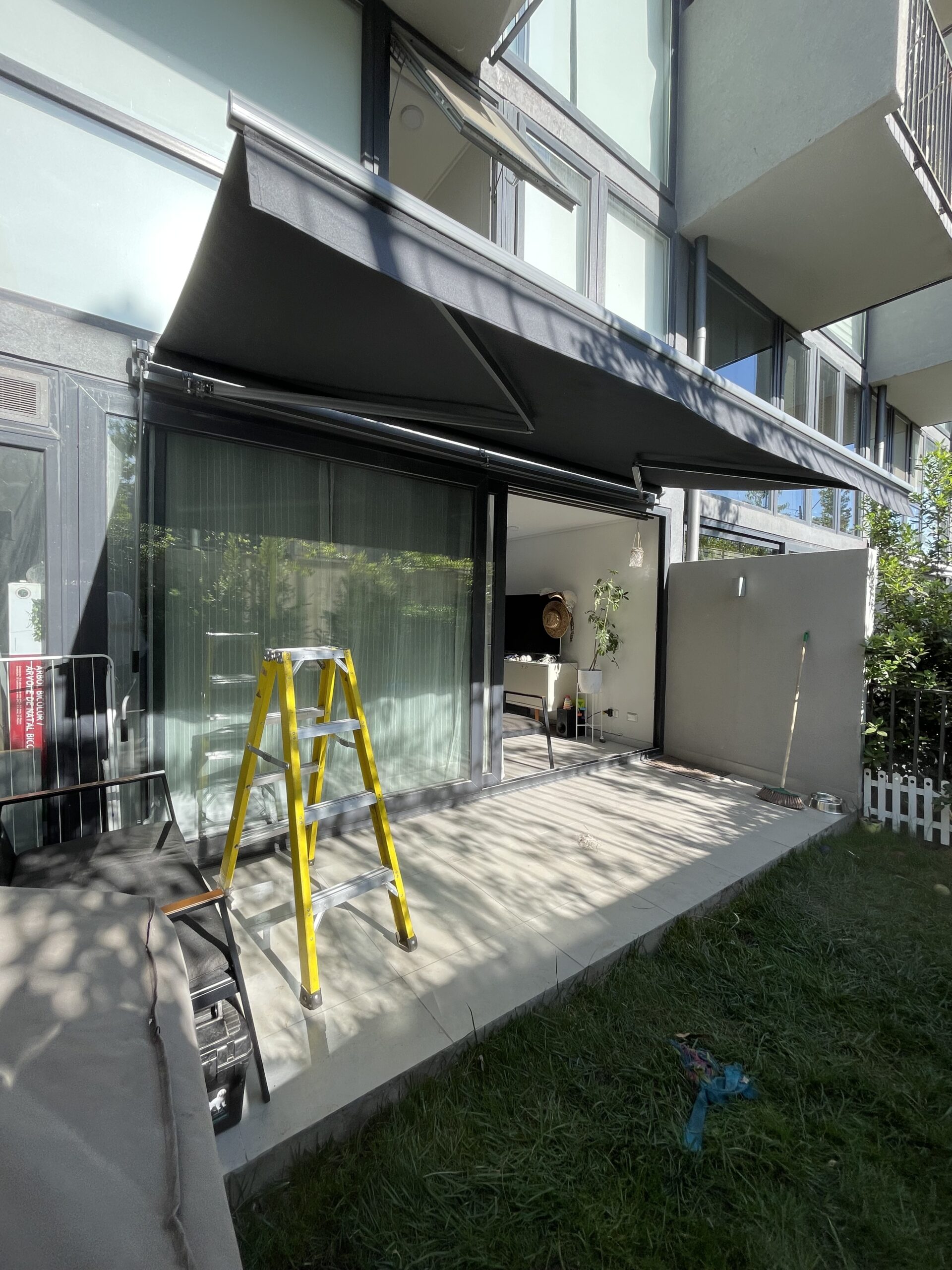 Terraza de departamento moderna con cierre de cristal plegable, amoblada con sofá. Terraza protegida del clima.