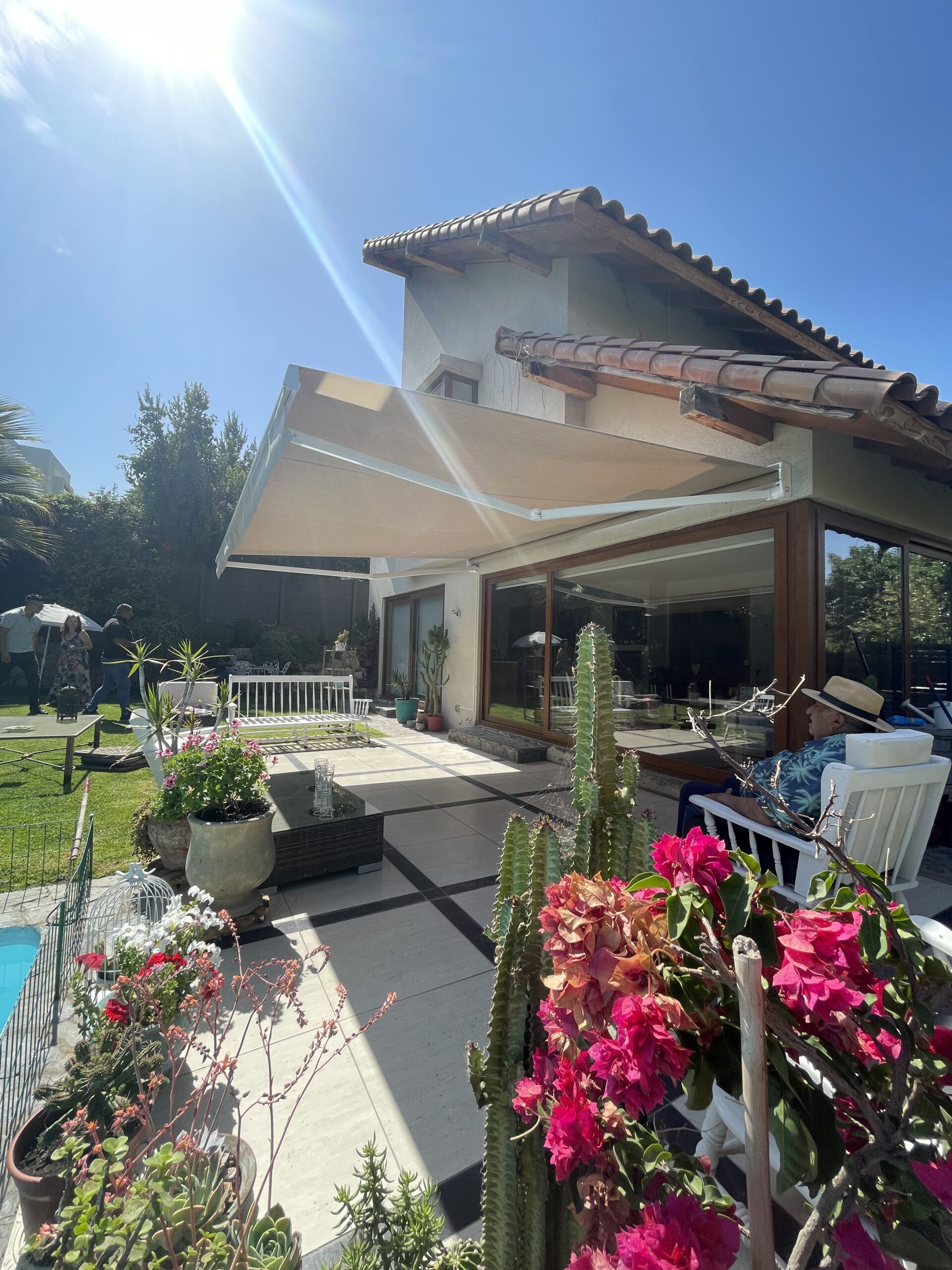 Terraza de departamento moderna con cierre de cristal plegable, amoblada con sofá. Terraza protegida del clima.