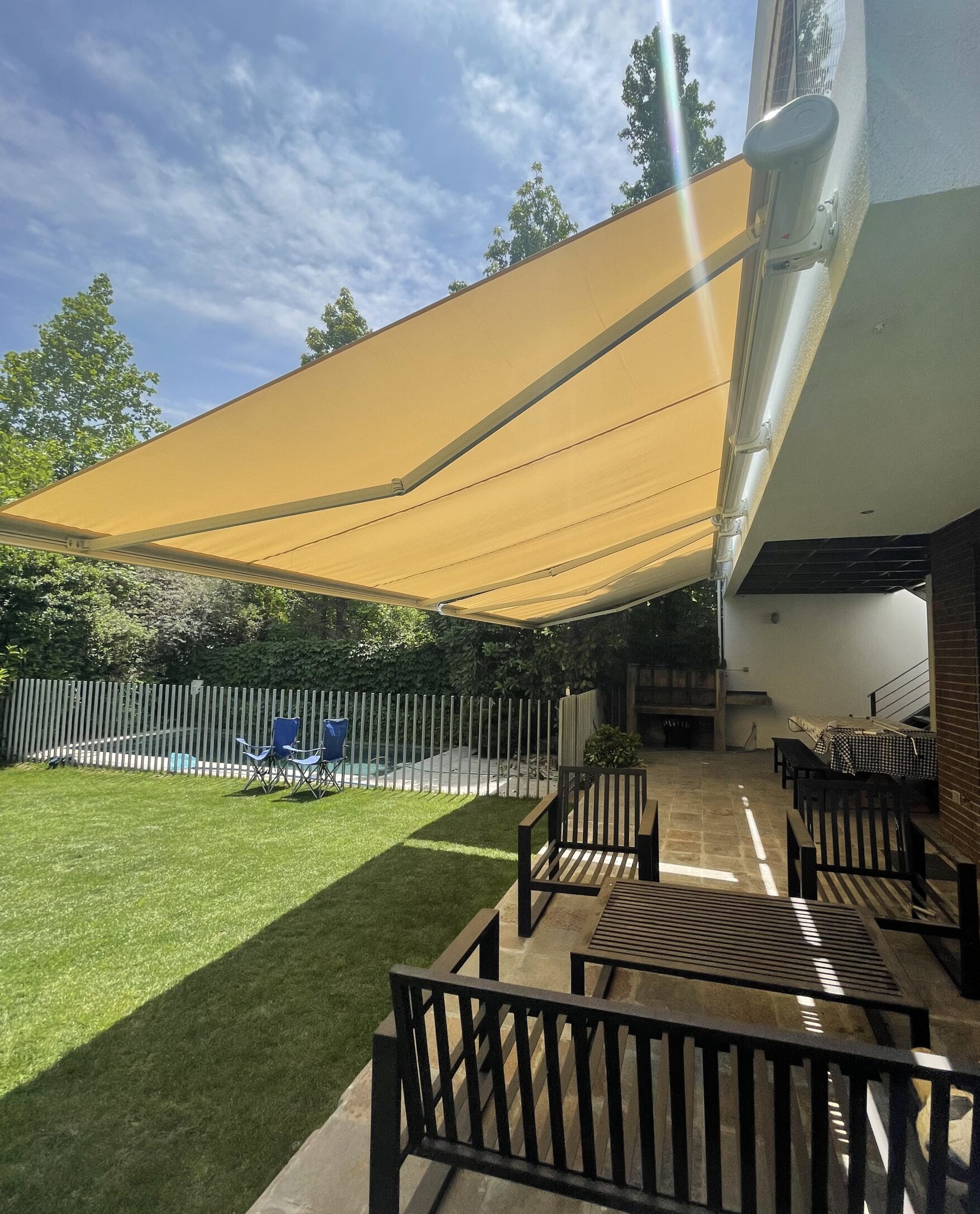 Terraza de departamento moderna con cierre de cristal plegable, amoblada con sofá. Terraza protegida del clima.