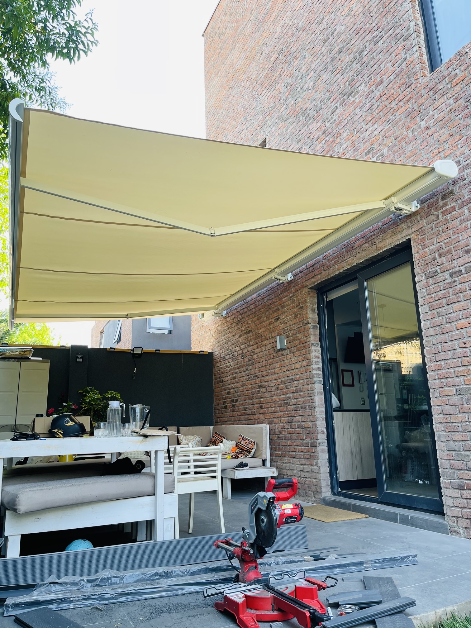 Terraza de departamento moderna con cierre de cristal plegable, amoblada con sofá. Terraza protegida del clima.