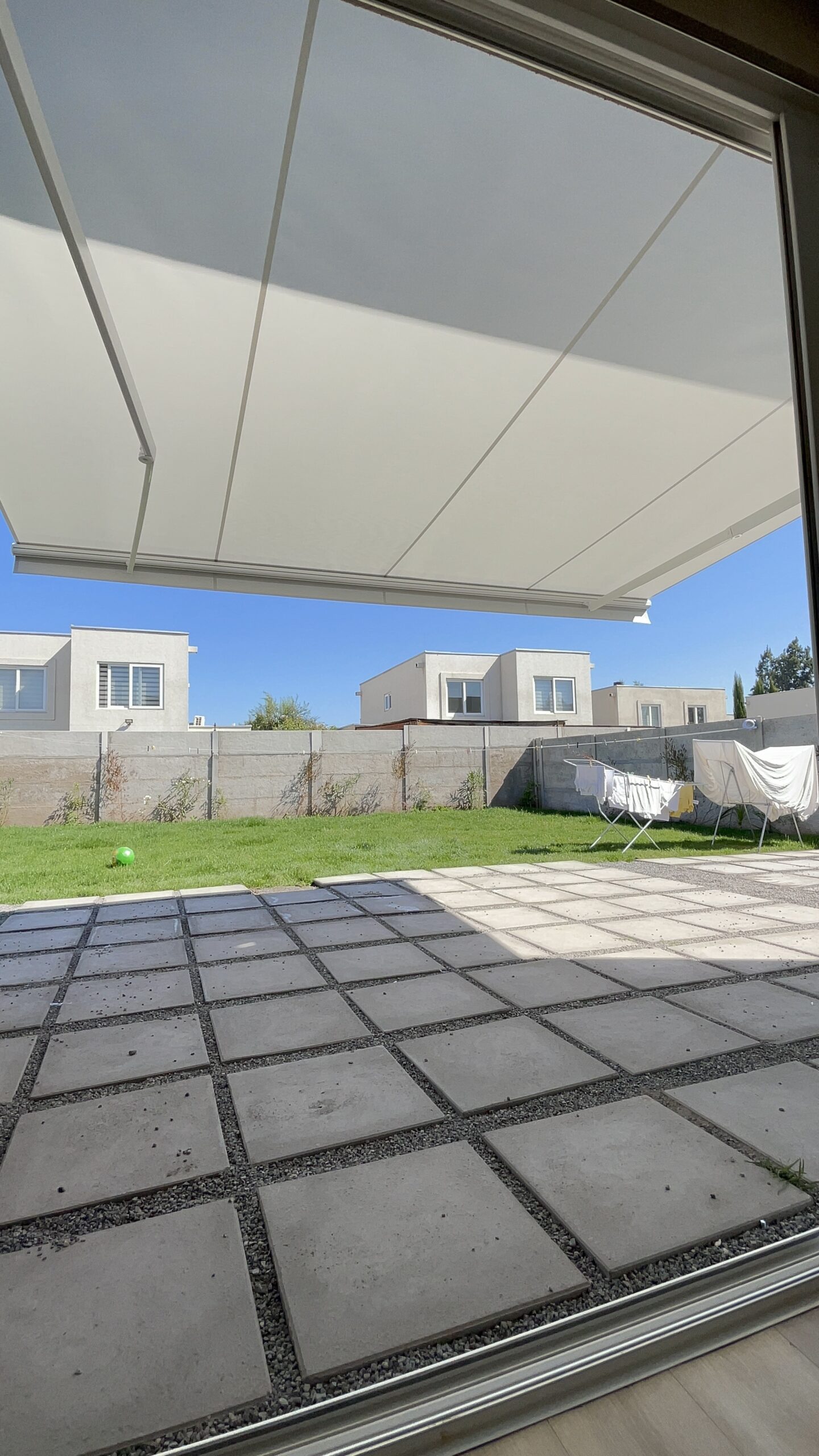 Terraza de departamento moderna con cierre de cristal plegable, amoblada con sofá. Terraza protegida del clima.