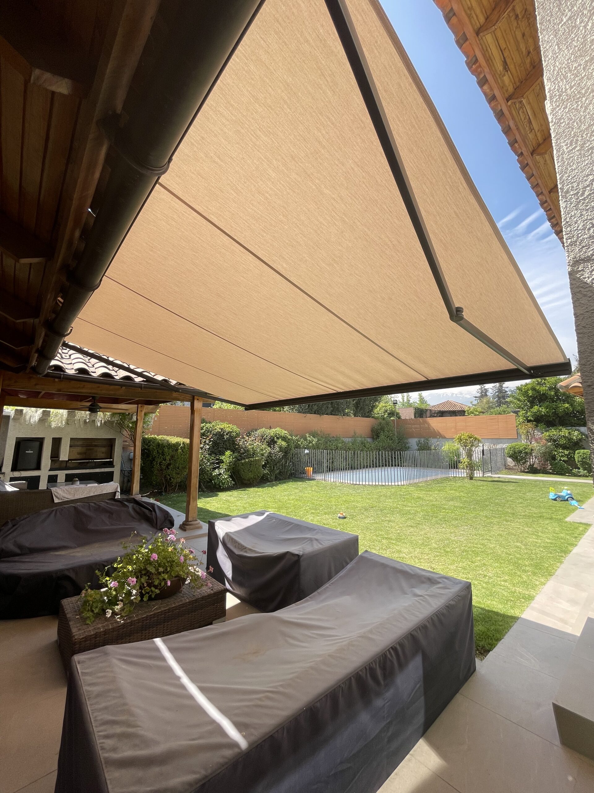 Terraza de departamento moderna con cierre de cristal plegable, amoblada con sofá. Terraza protegida del clima.