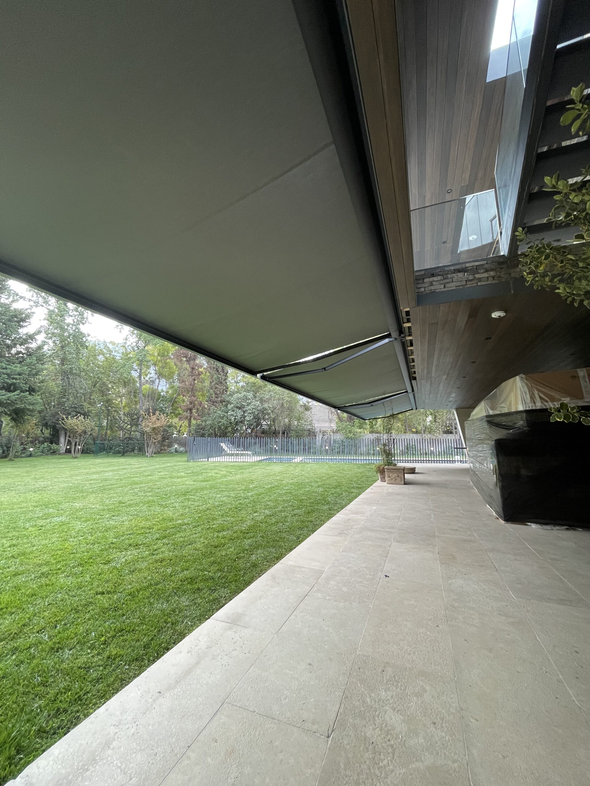 Terraza de departamento moderna con cierre de cristal plegable, amoblada con sofá. Terraza protegida del clima.