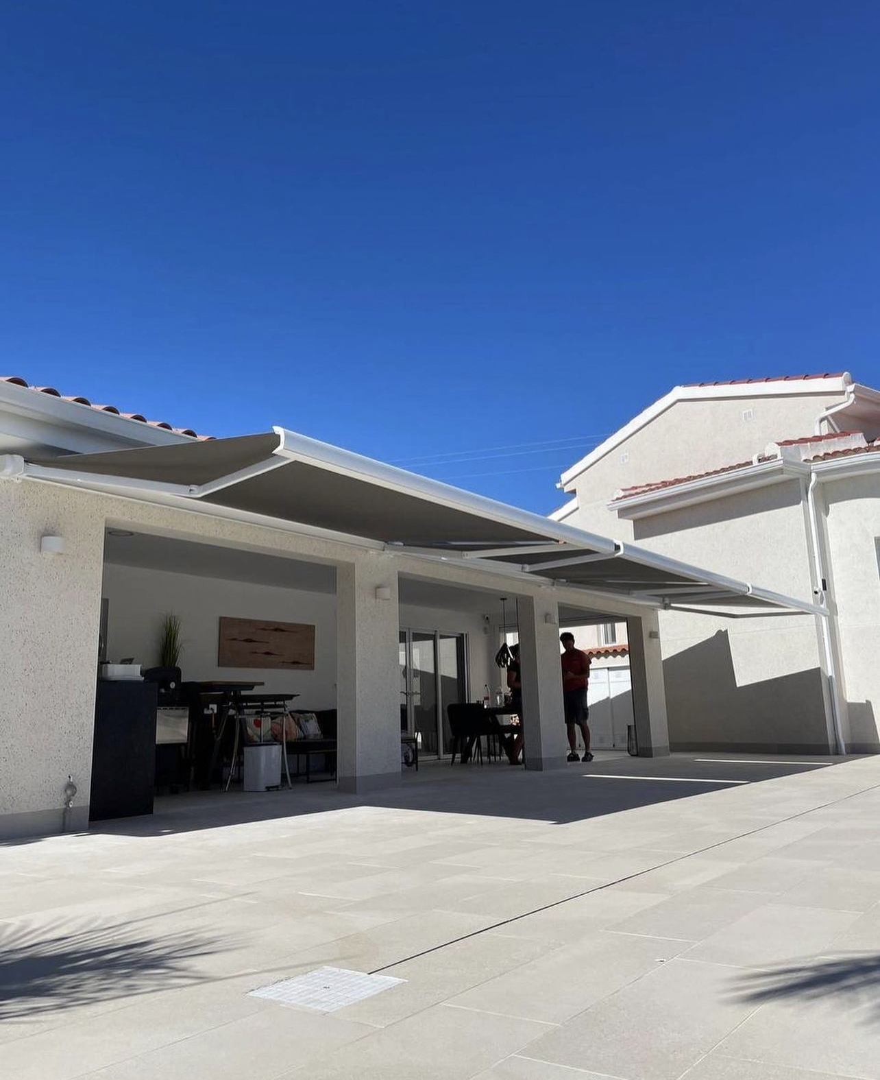 Terraza de departamento moderna con cierre de cristal plegable, amoblada con sofá. Terraza protegida del clima.