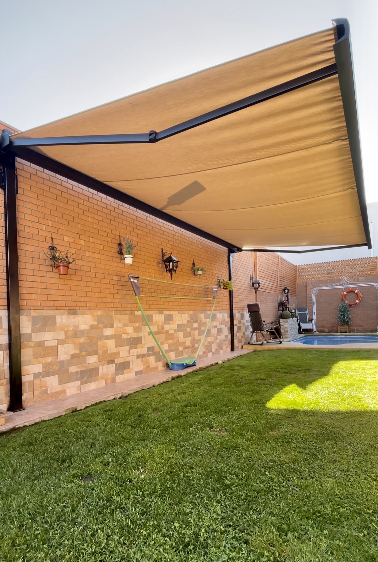 Terraza de departamento moderna con cierre de cristal plegable, amoblada con sofá. Terraza protegida del clima.