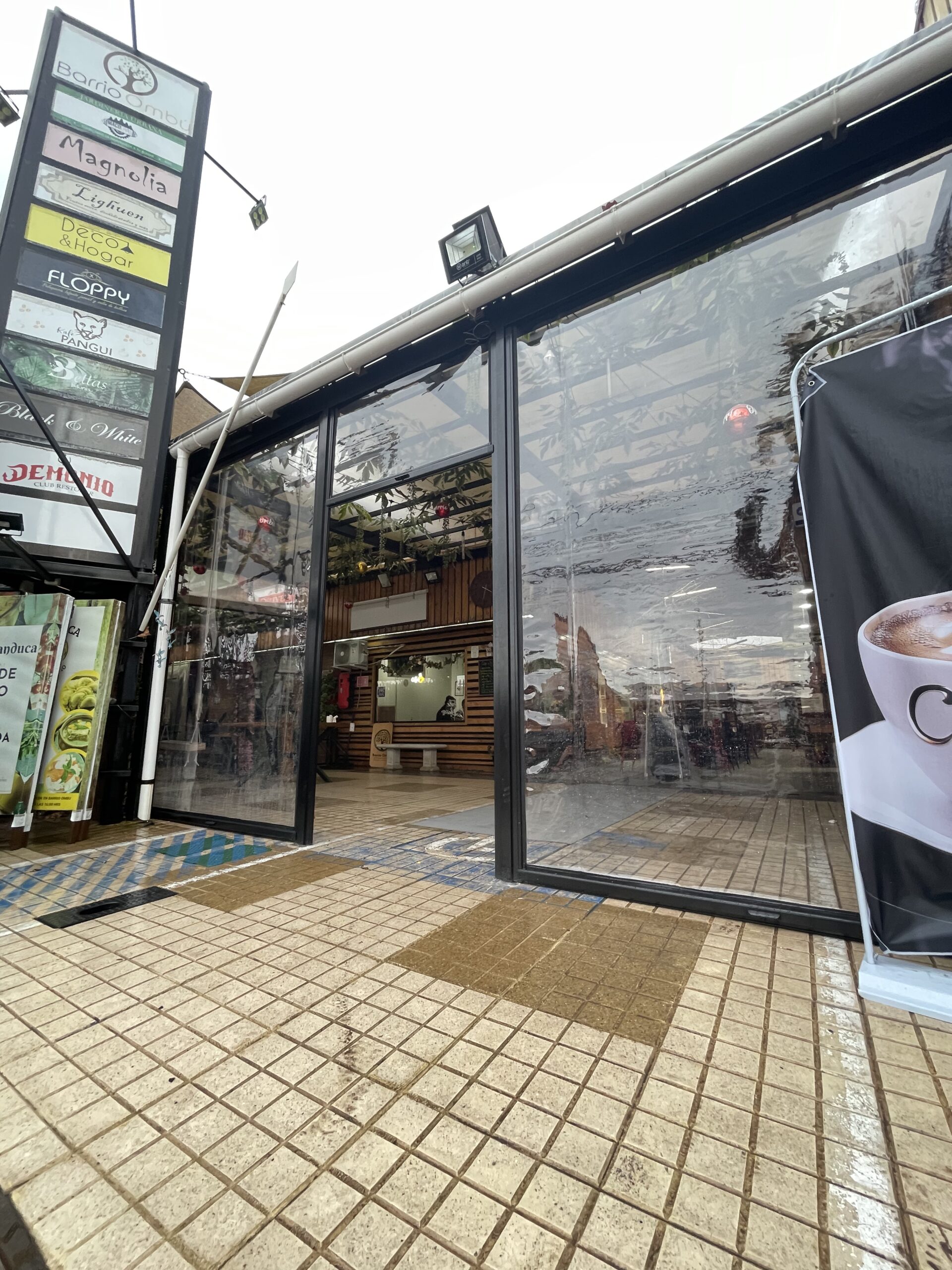 Terraza de departamento moderna con cierre de cristal plegable, amoblada con sofá. Terraza protegida del clima.