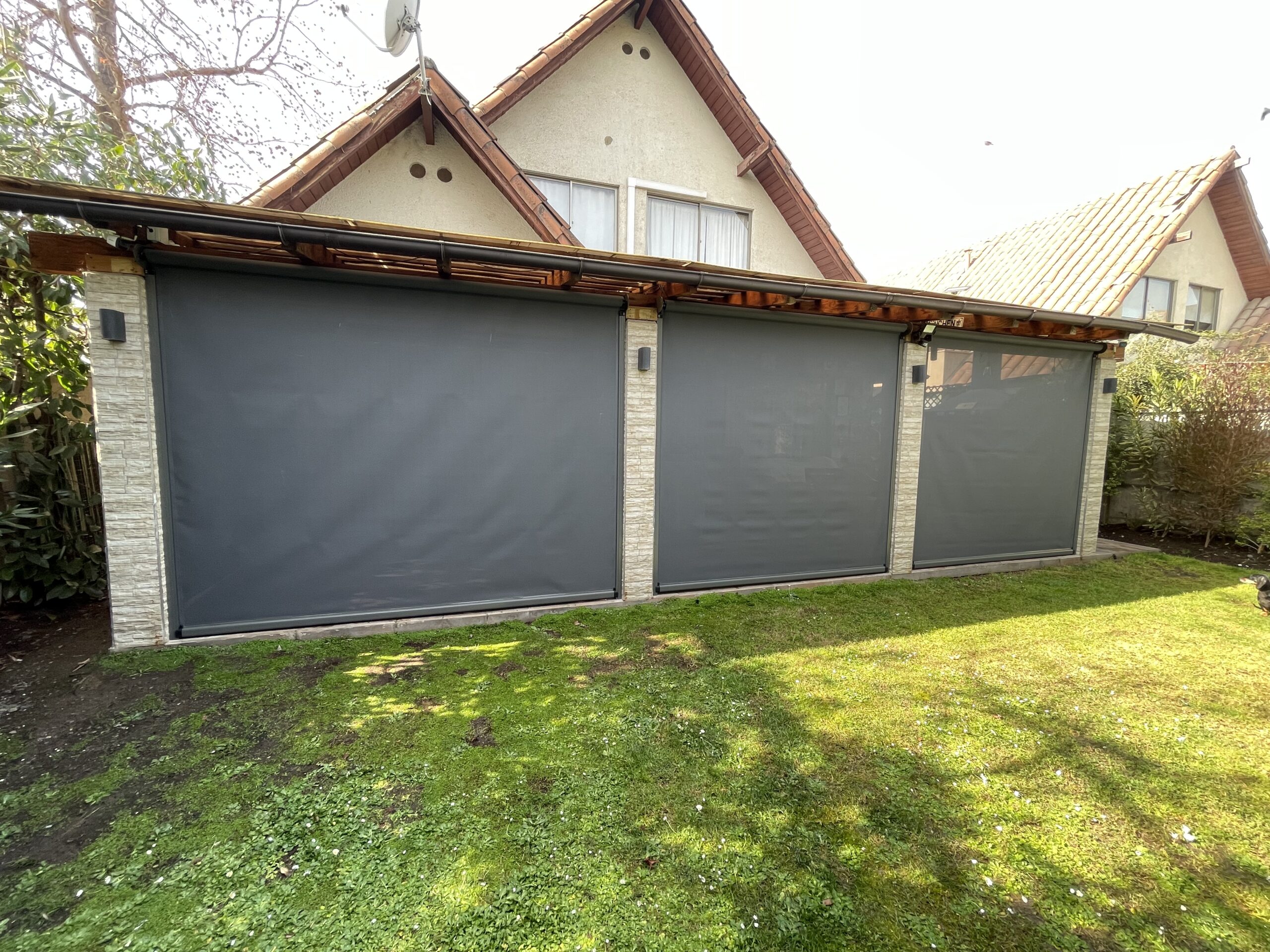 Terraza de departamento moderna con cierre de cristal plegable, amoblada con sofá. Terraza protegida del clima.