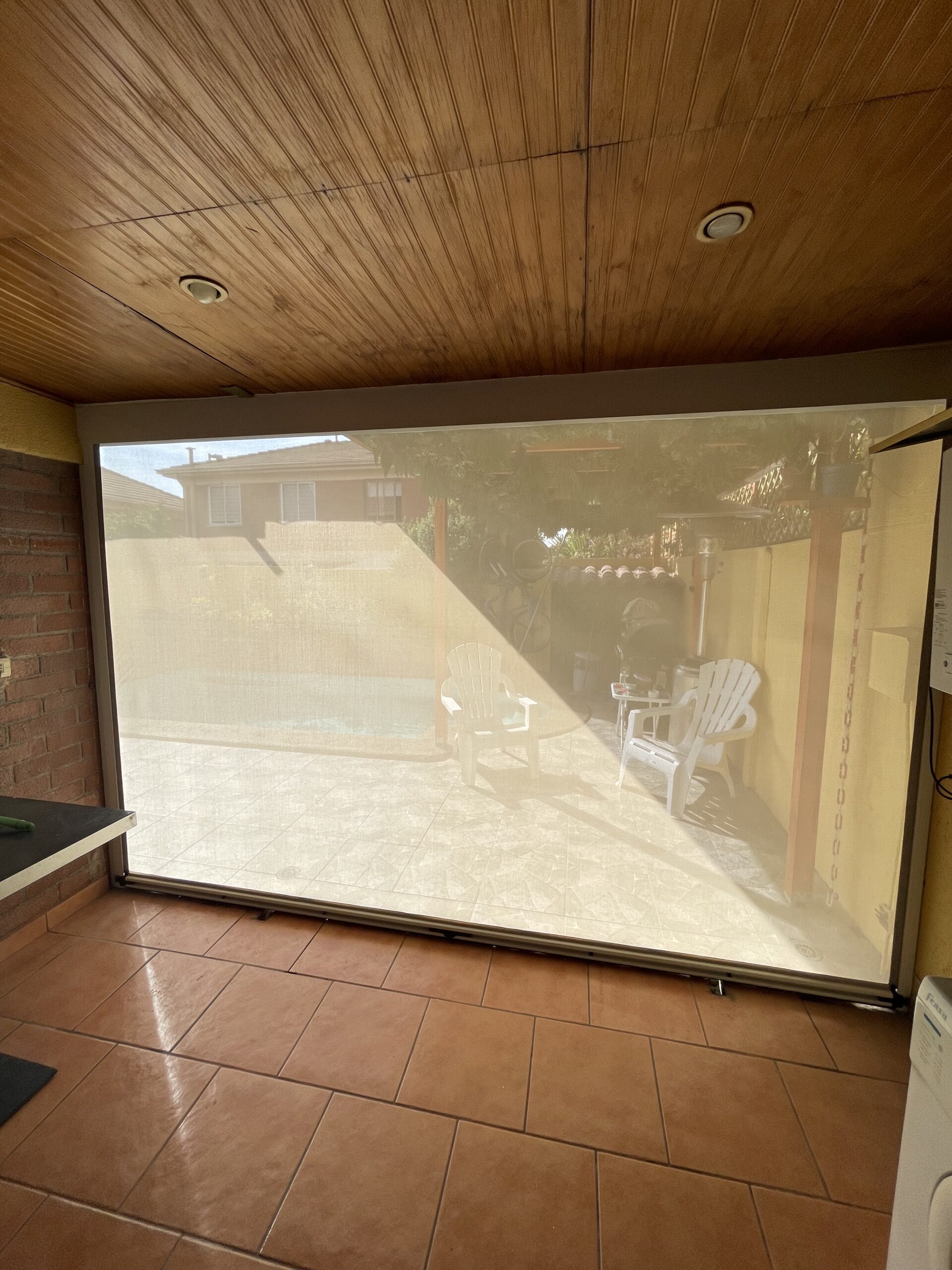 Terraza de departamento moderna con cierre de cristal plegable, amoblada con sofá. Terraza protegida del clima.