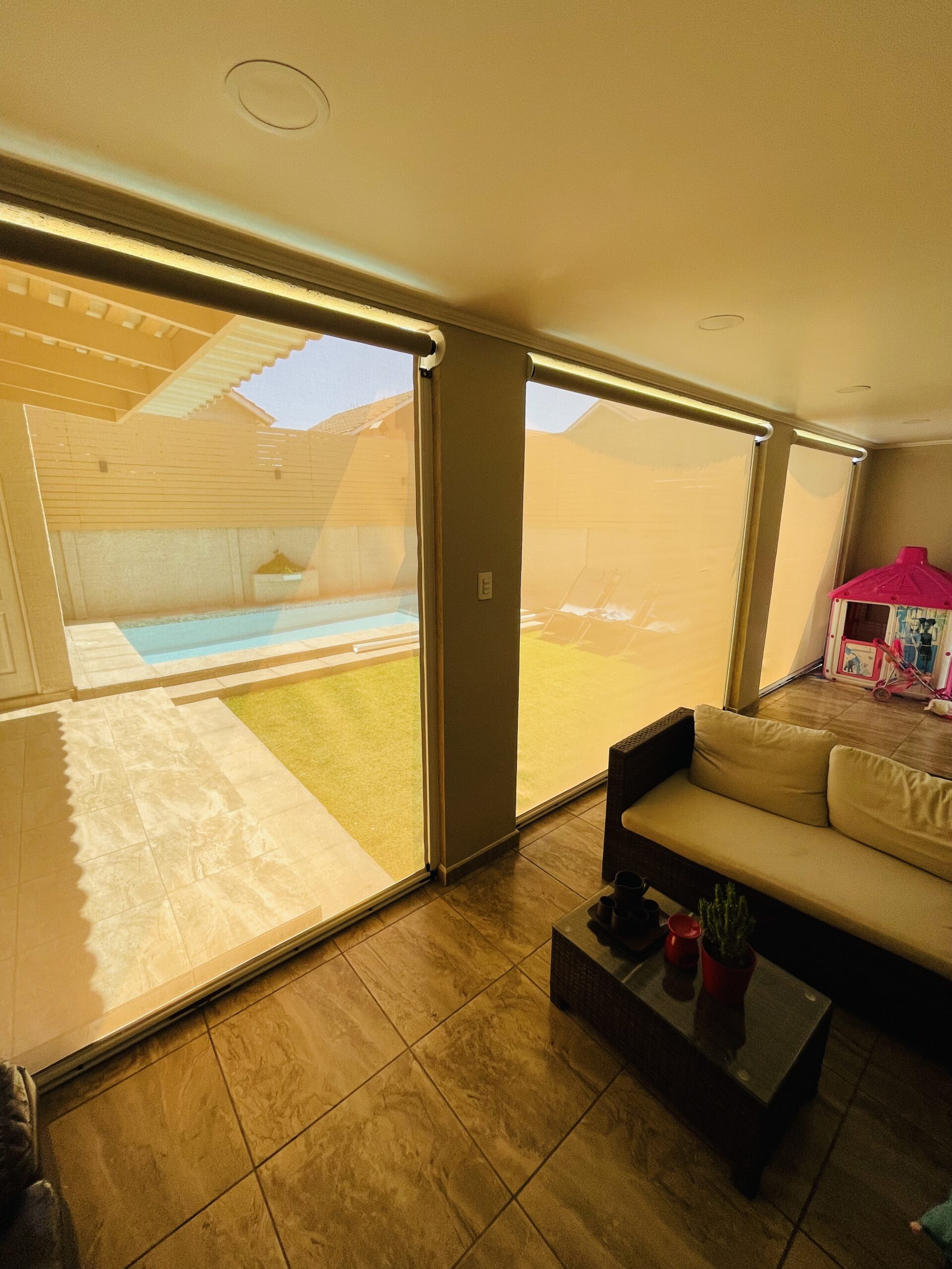 Terraza de departamento moderna con cierre de cristal plegable, amoblada con sofá. Terraza protegida del clima.