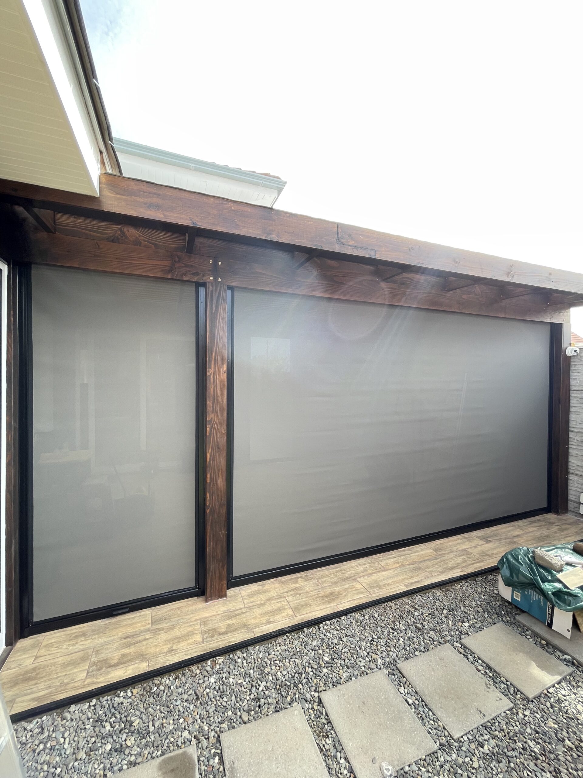 Terraza de departamento moderna con cierre de cristal plegable, amoblada con sofá. Terraza protegida del clima.