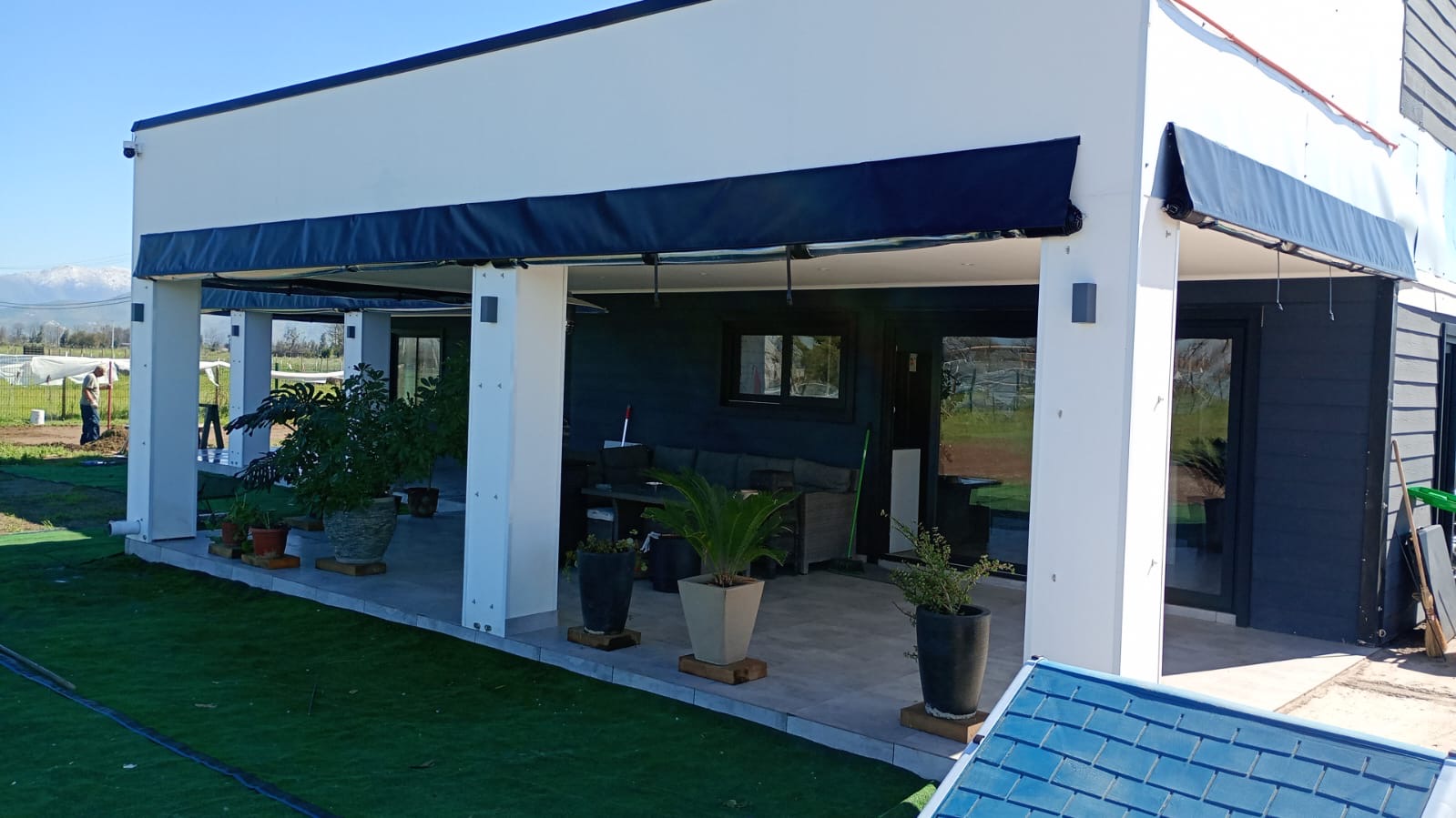 Terraza de departamento moderna con cierre de cristal plegable, amoblada con sofá. Terraza protegida del clima.