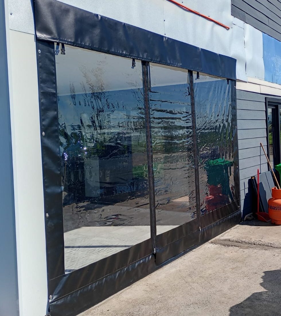 Terraza de departamento moderna con cierre de cristal plegable, amoblada con sofá. Terraza protegida del clima.