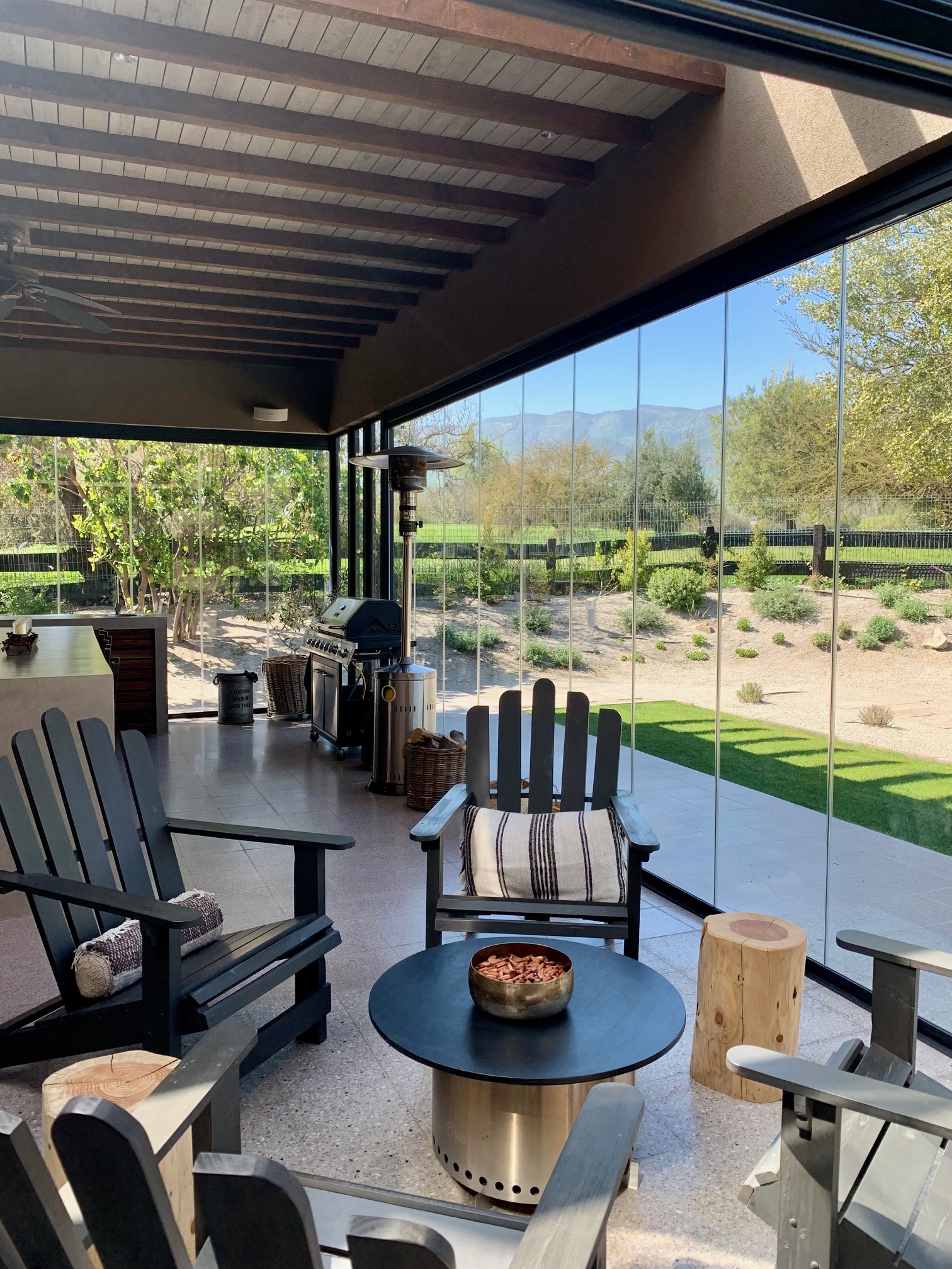 Terraza de departamento moderna con cierre de cristal plegable, amoblada con sofá. Terraza protegida del clima.