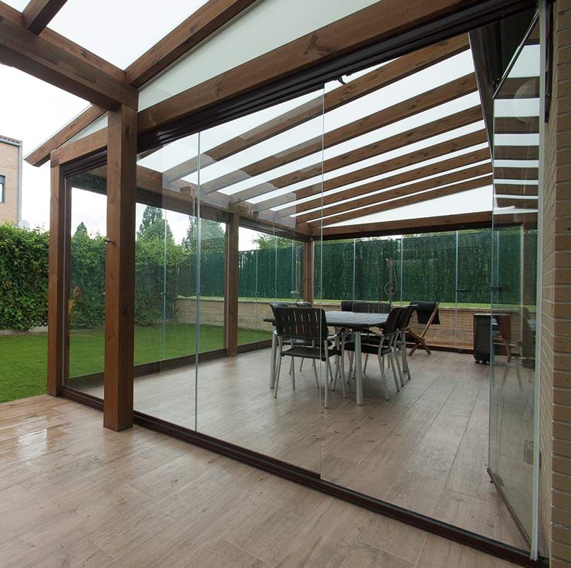 Terraza de departamento moderna con cierre de cristal plegable, amoblada con sofá. Terraza protegida del clima.