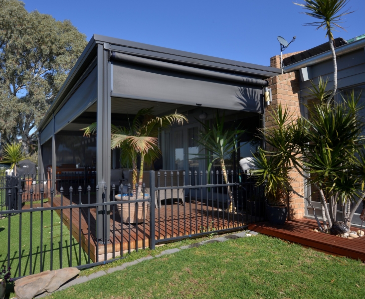 Terraza de departamento moderna con cierre de cristal plegable, amoblada con sofá. Terraza protegida del clima.
