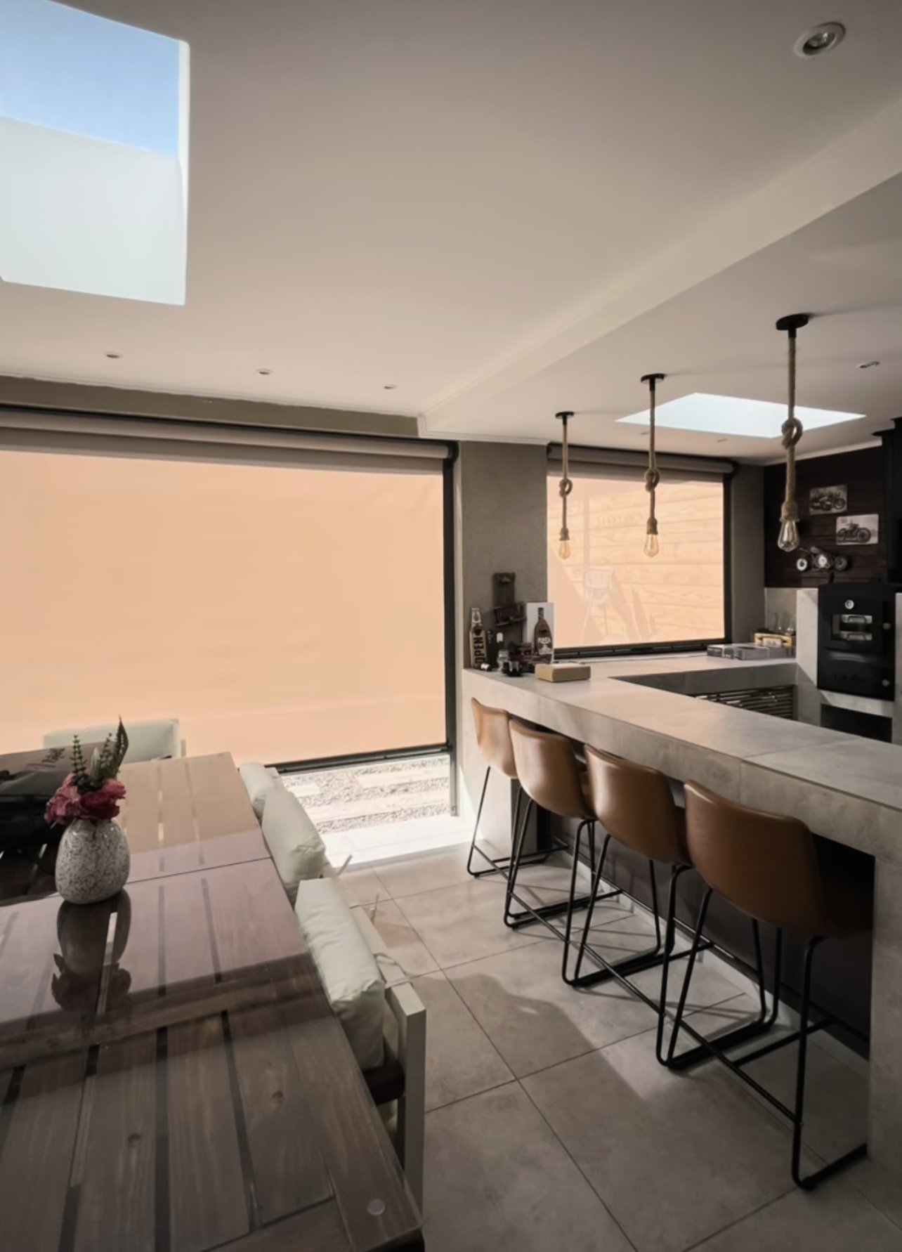 Terraza de departamento moderna con cierre de cristal plegable, amoblada con sofá. Terraza protegida del clima.