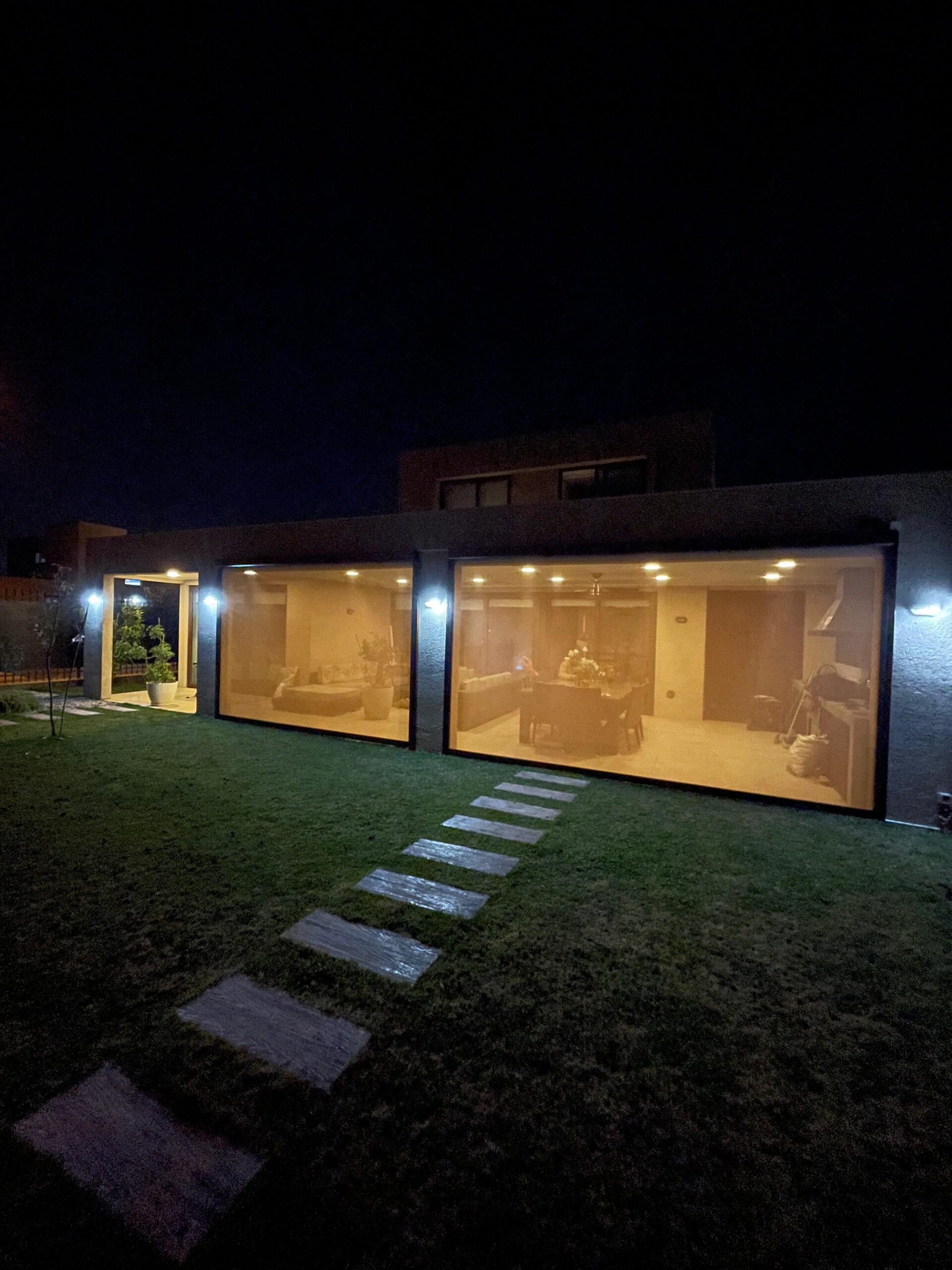 Terraza de departamento moderna con cierre de cristal plegable, amoblada con sofá. Terraza protegida del clima.