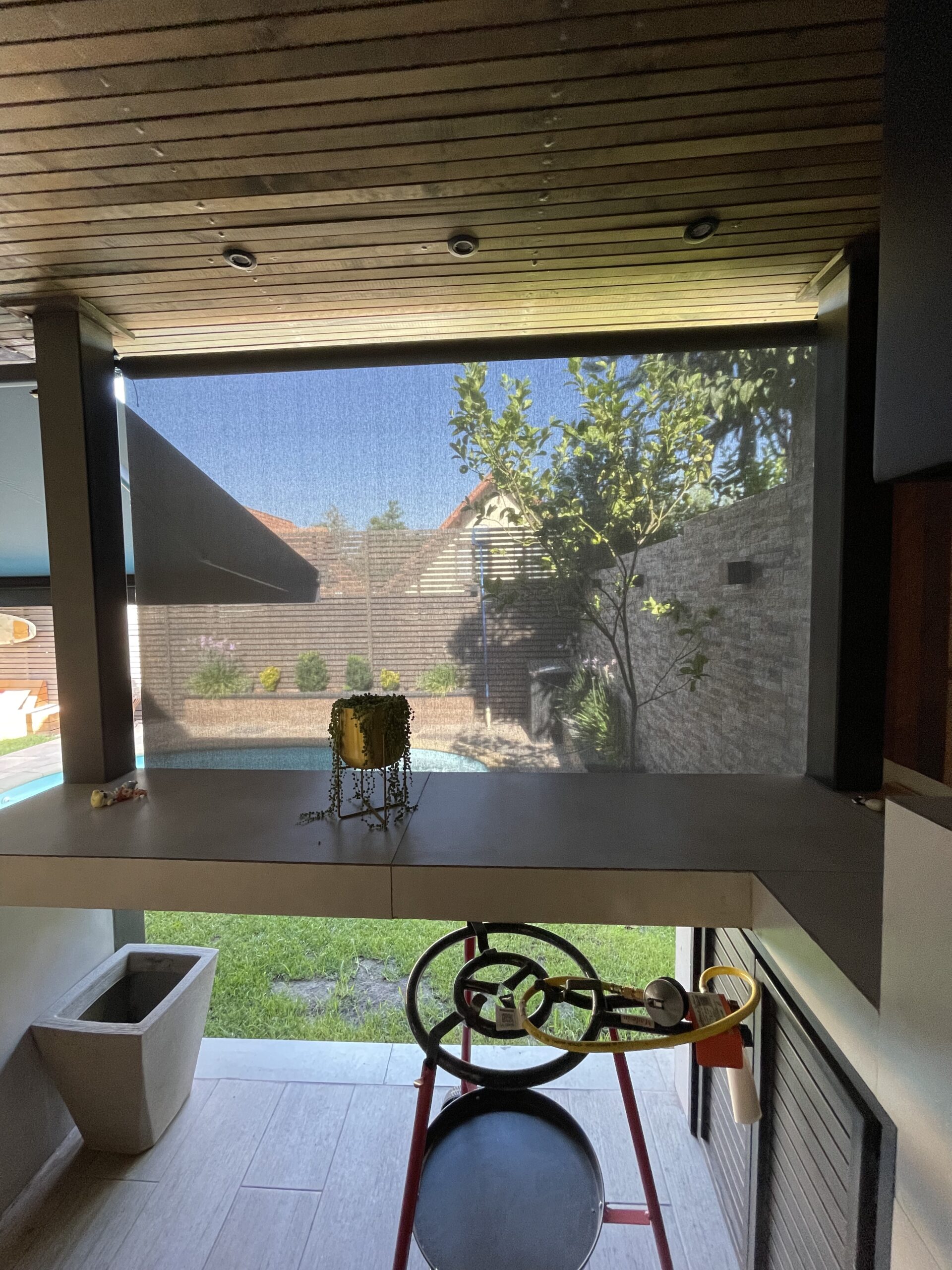 Terraza de departamento moderna con cierre de cristal plegable, amoblada con sofá. Terraza protegida del clima.