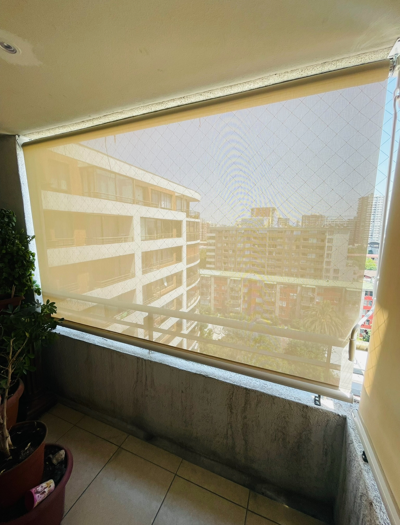 Terraza de departamento moderna con cierre de cristal plegable, amoblada con sofá. Terraza protegida del clima.