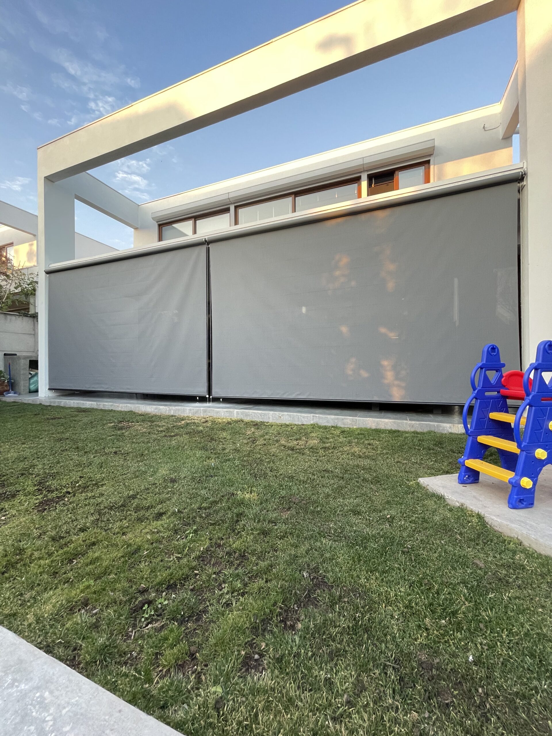 Terraza de departamento moderna con cierre de cristal plegable, amoblada con sofá. Terraza protegida del clima.