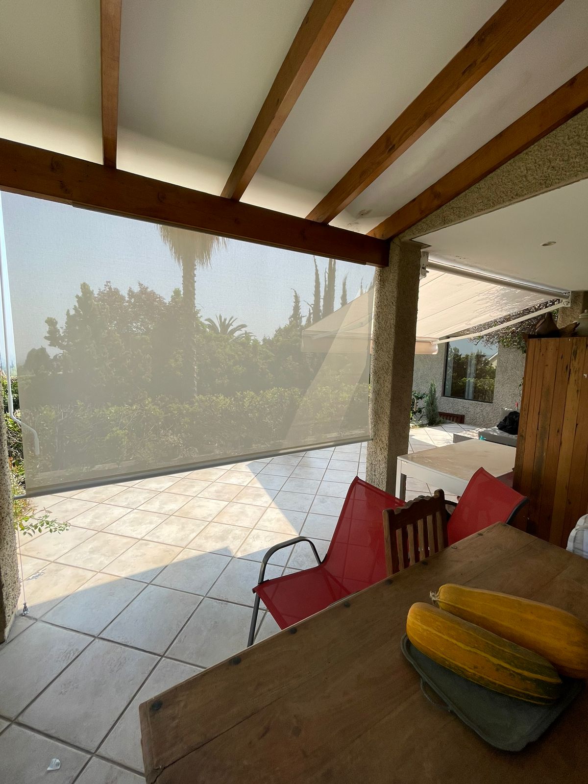 Terraza de departamento moderna con cierre de cristal plegable, amoblada con sofá. Terraza protegida del clima.