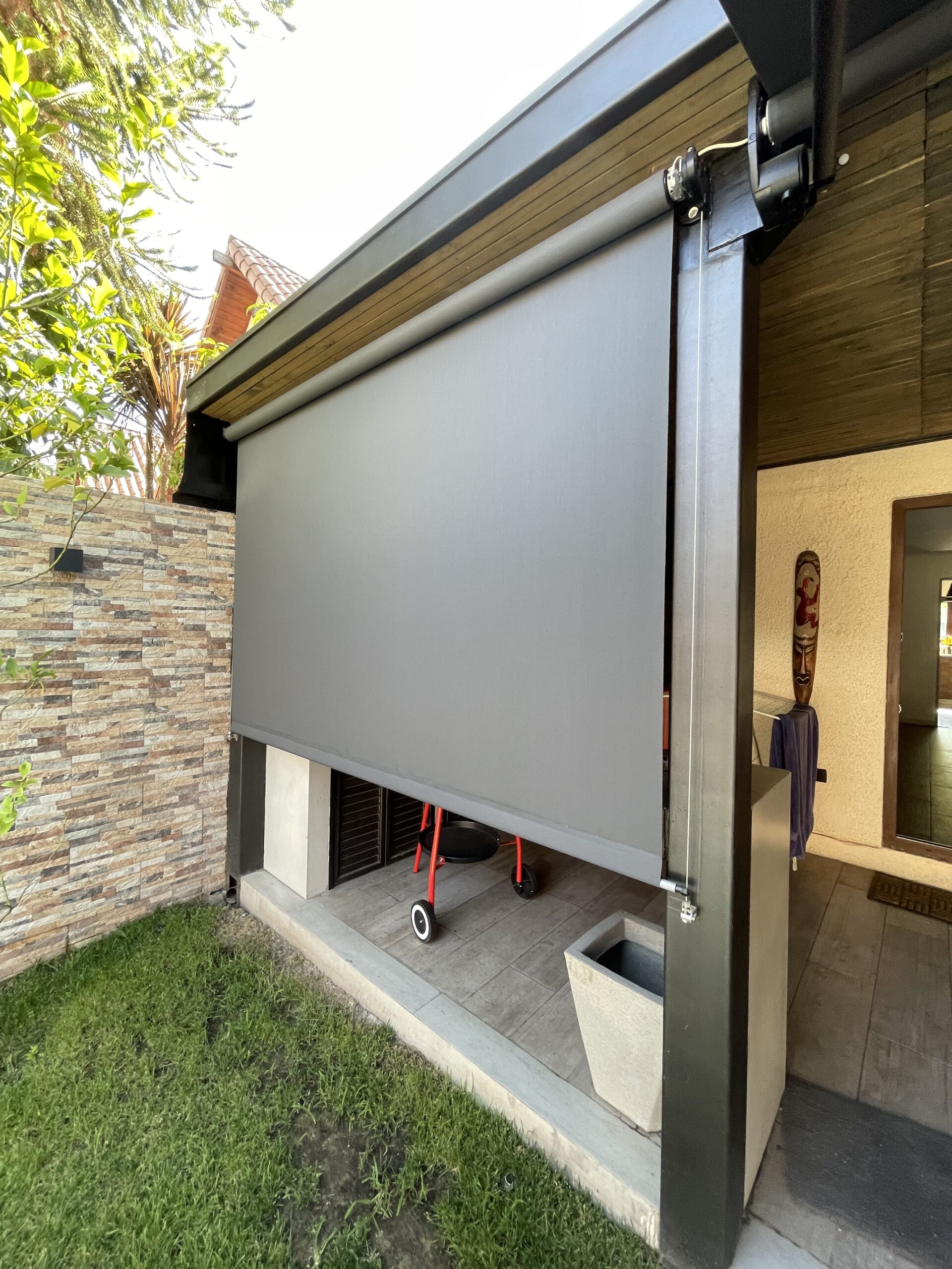 Terraza de departamento moderna con cierre de cristal plegable, amoblada con sofá. Terraza protegida del clima.