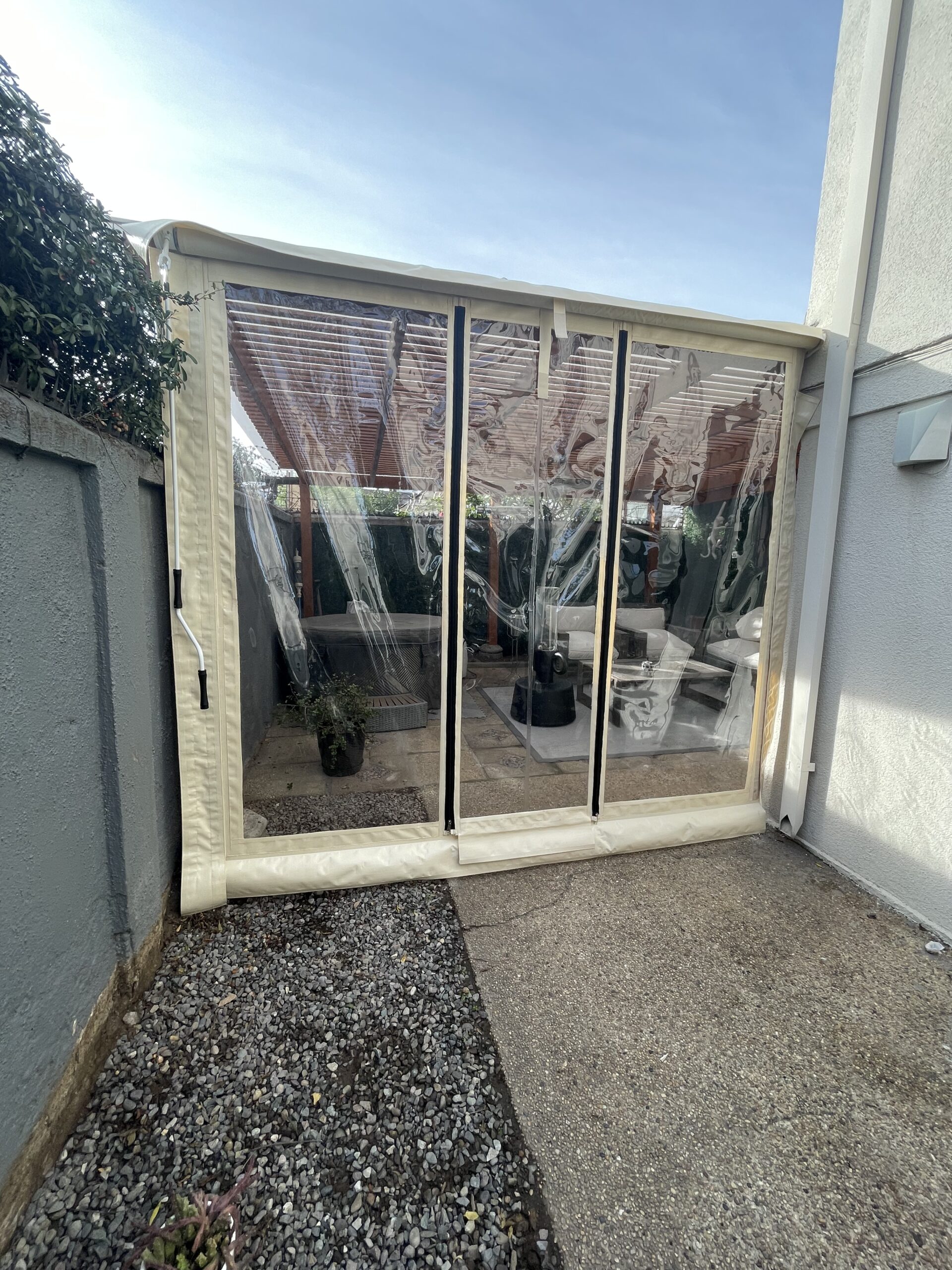 Terraza de departamento moderna con cierre de cristal plegable, amoblada con sofá. Terraza protegida del clima.
