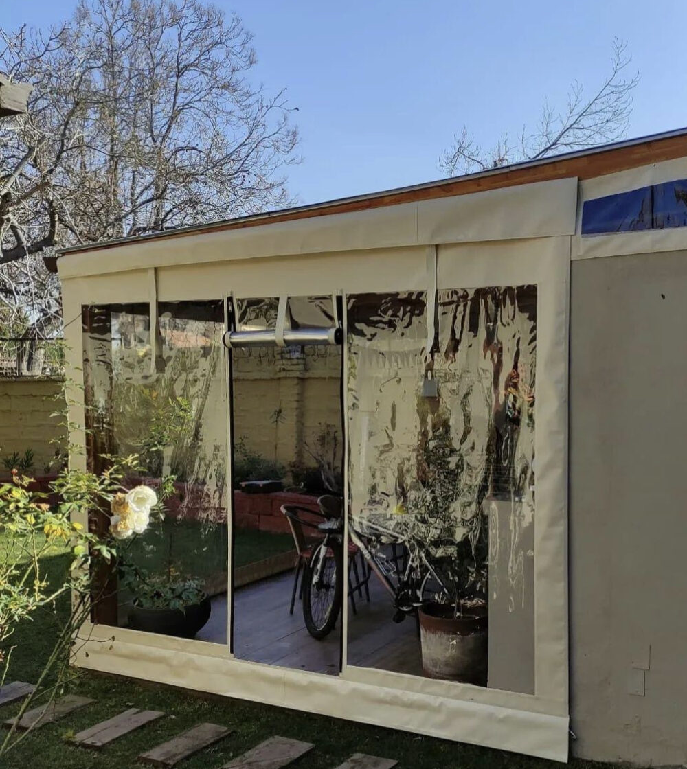 Terraza de departamento moderna con cierre de cristal plegable, amoblada con sofá. Terraza protegida del clima.