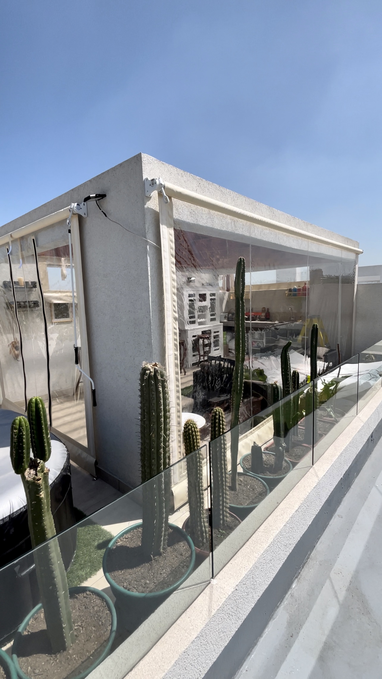 Terraza de departamento moderna con cierre de cristal plegable, amoblada con sofá. Terraza protegida del clima.