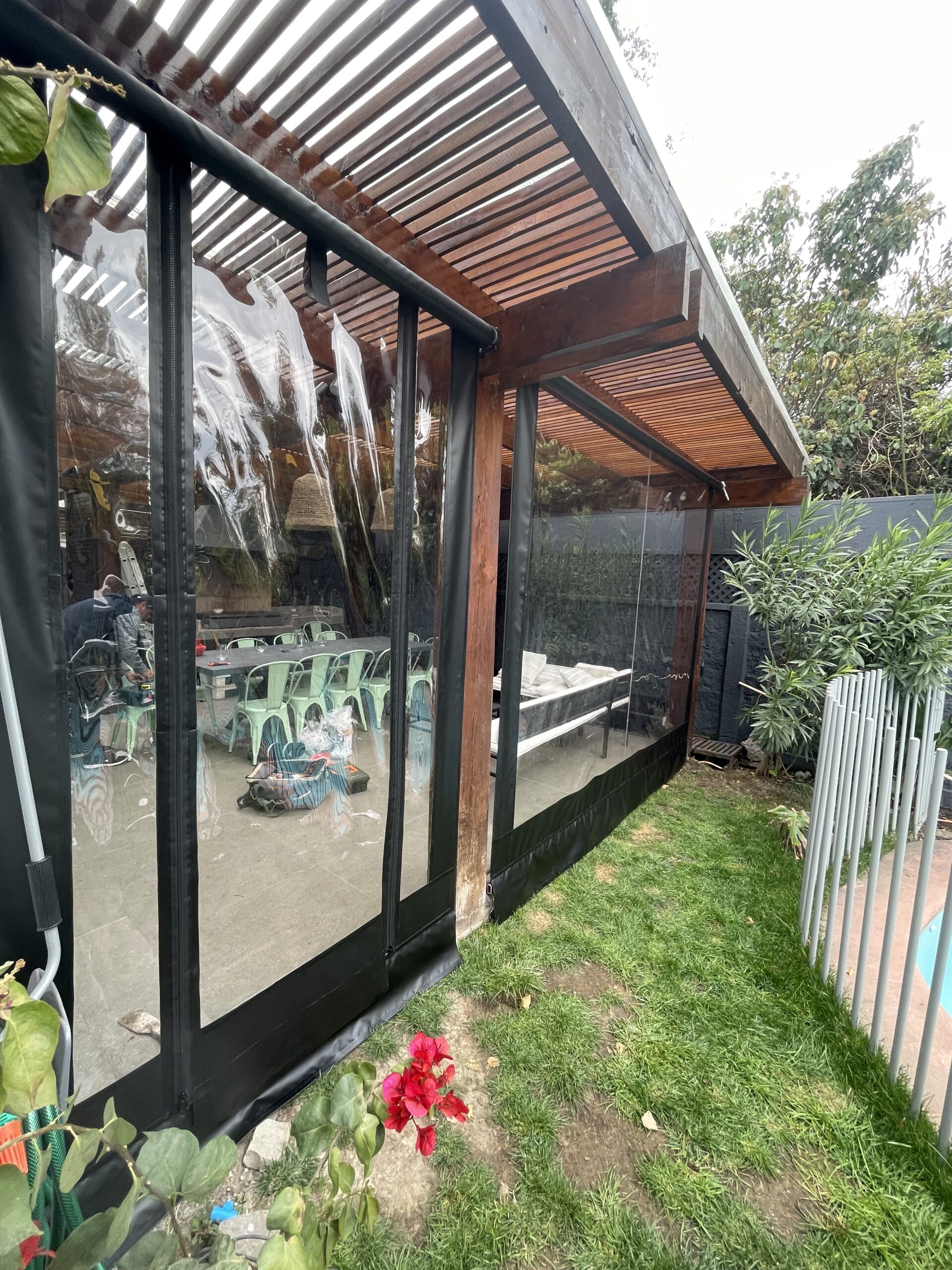 Terraza de departamento moderna con cierre de cristal plegable, amoblada con sofá. Terraza protegida del clima.